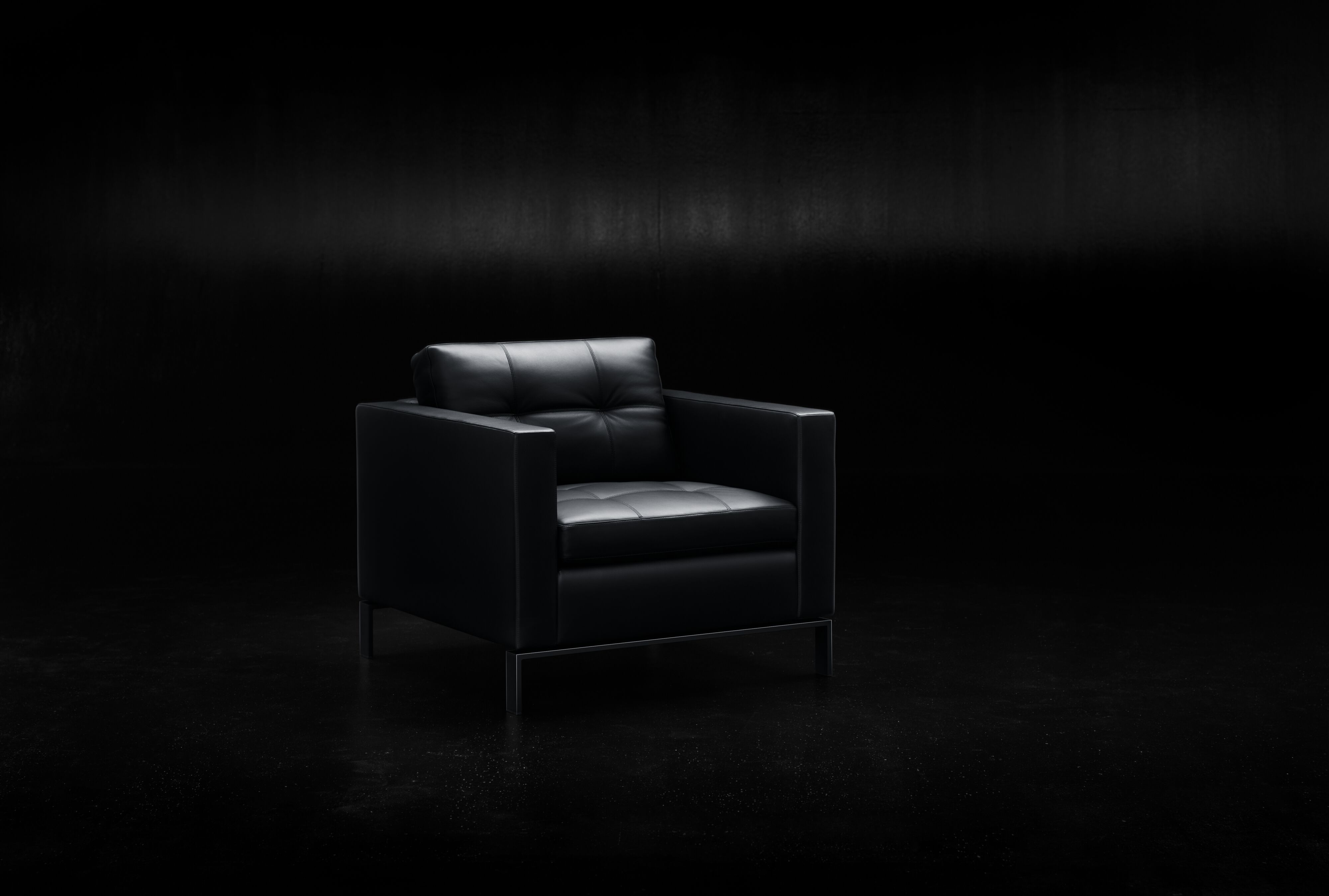Schwarzer 502 Foster Sessel von Walter Knoll mit Lederbezug und minimalistischem Design auf dunklem Hintergrund.