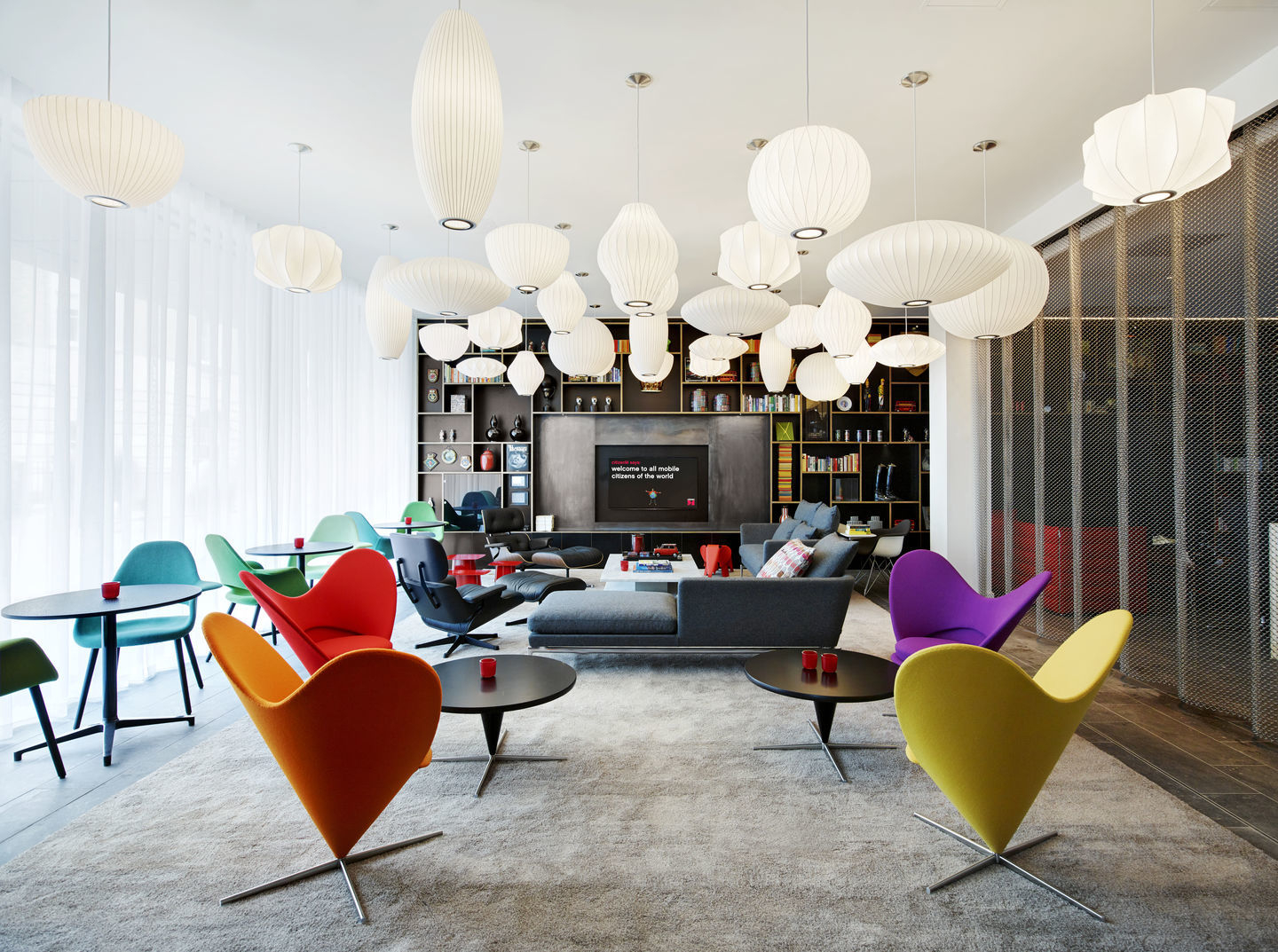 Helle, moderne Lounge mit vielen Akari Pendelleuchten von Vitra, Designklassiker für stimmungsvolle Beleuchtung im Wohnraum.