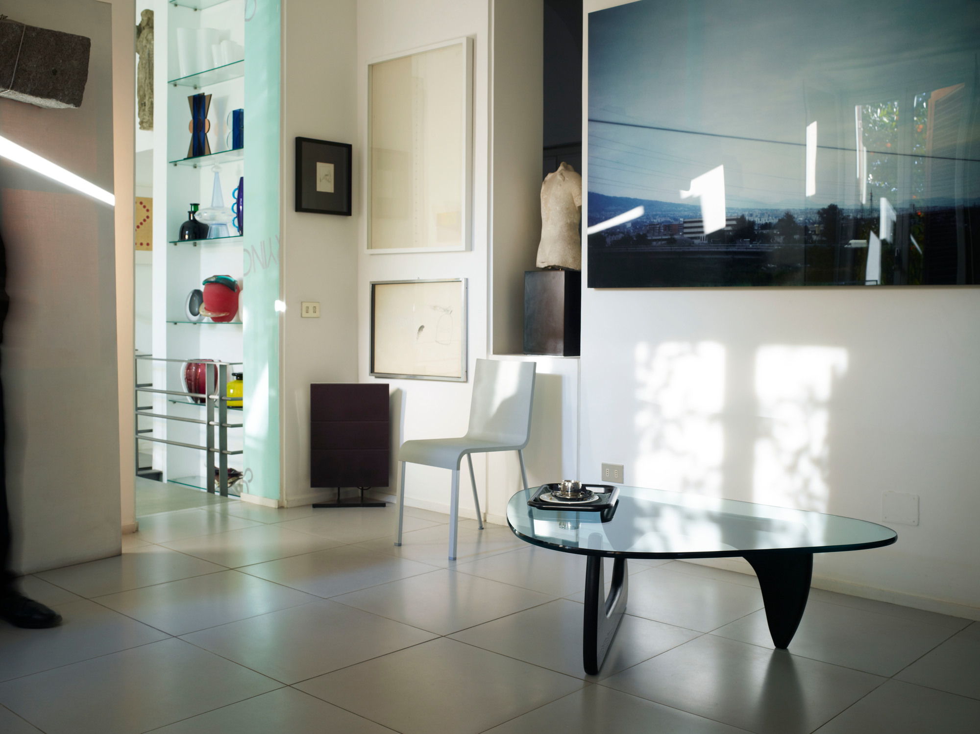 Noguchi Coffee Table Couchtisch Vitra im modernen Wohnzimmer mit Glasplatte und schwarzem Holzfuß.