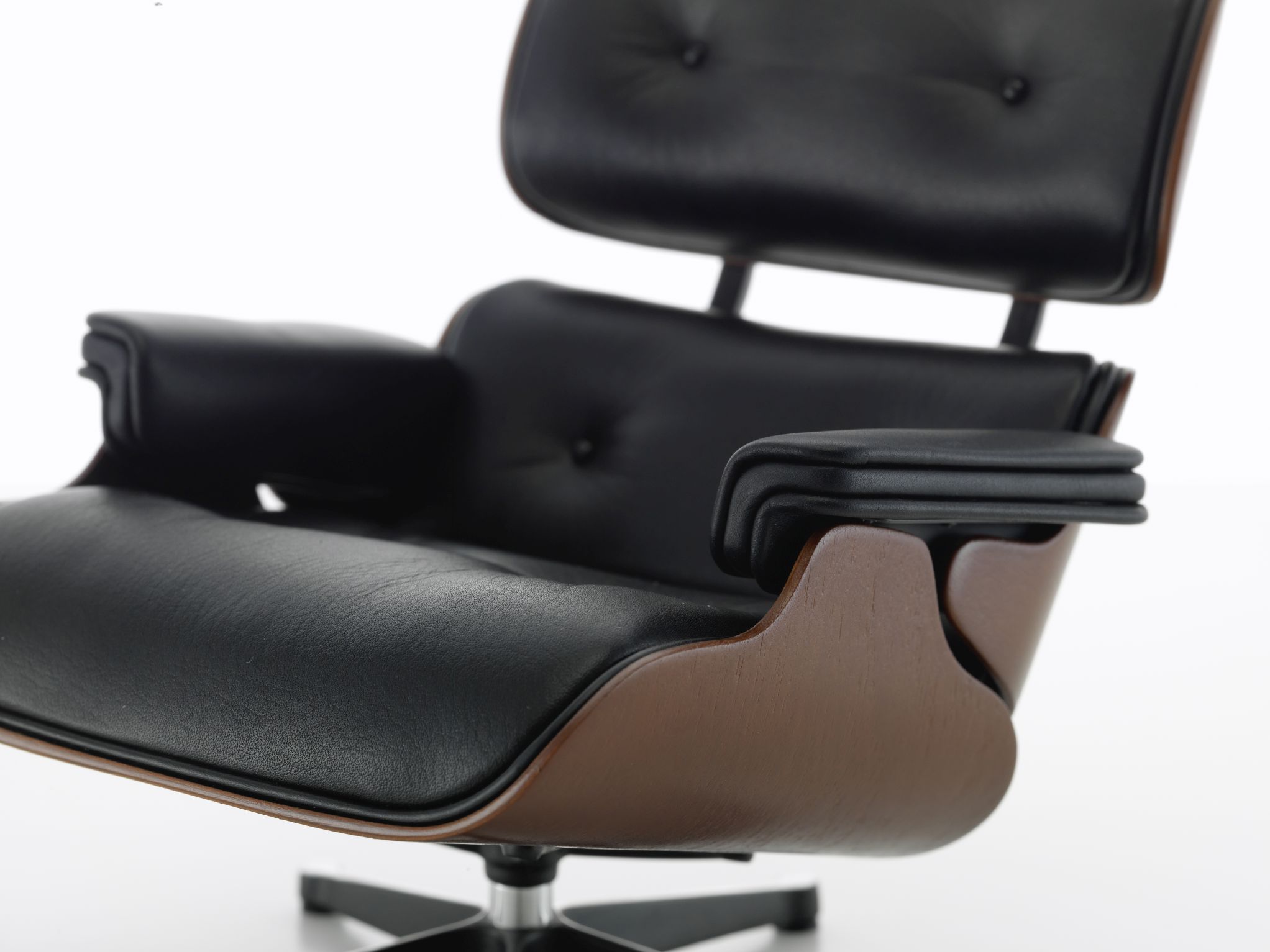 Detailaufnahme: Miniatur Lounge Chair von Vitra, schwarzes Leder, dunkles Holz, Designklassiker.