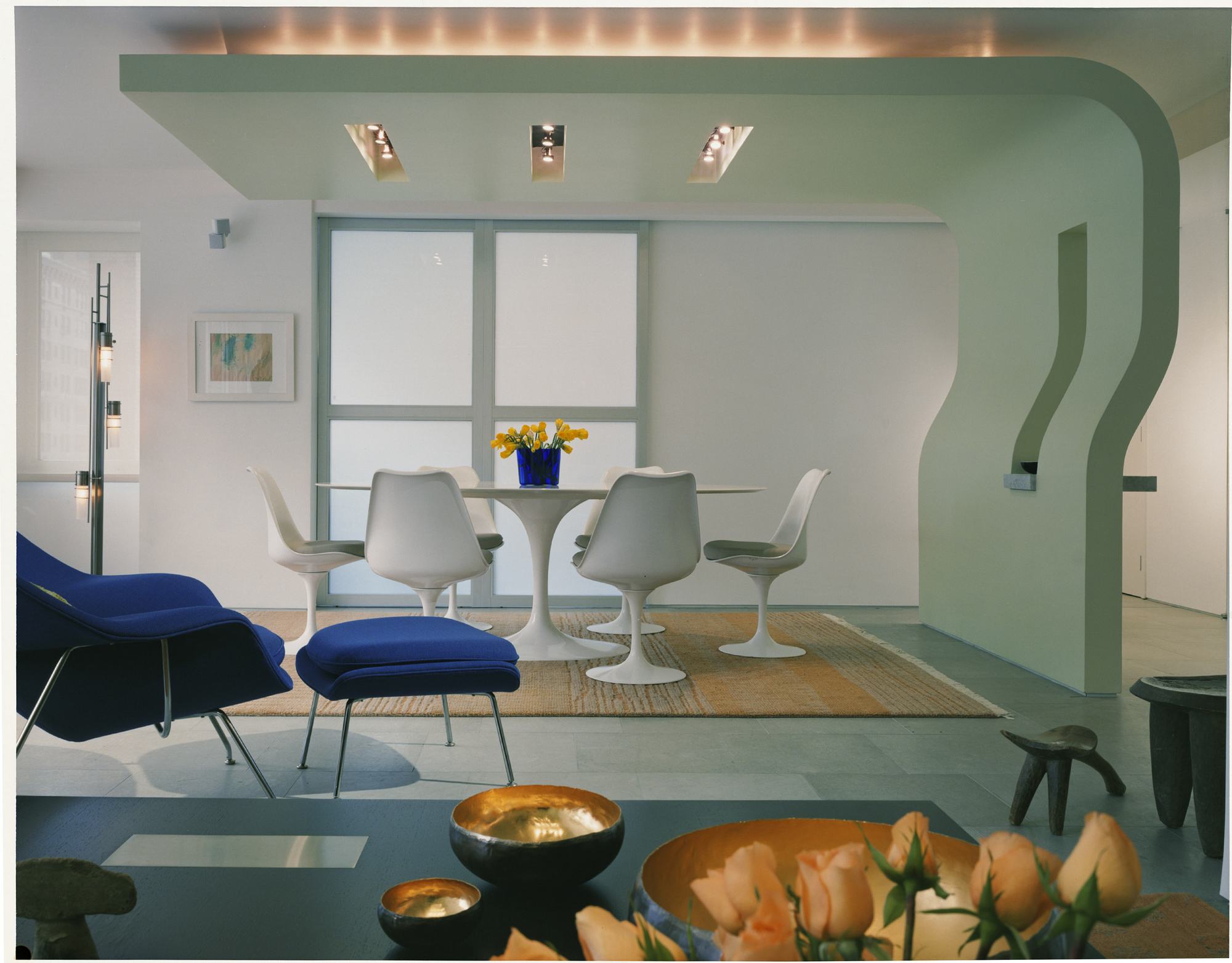 Esszimmer mit weißen Tulip Chair Stühlen von Knoll International um einen runden Esstisch.