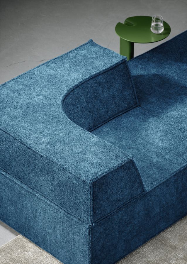 Detailaufnahme des blauen Trio Sofa Modulsofas von Cor mit grünen Beistelltisch und Wasserglas.
