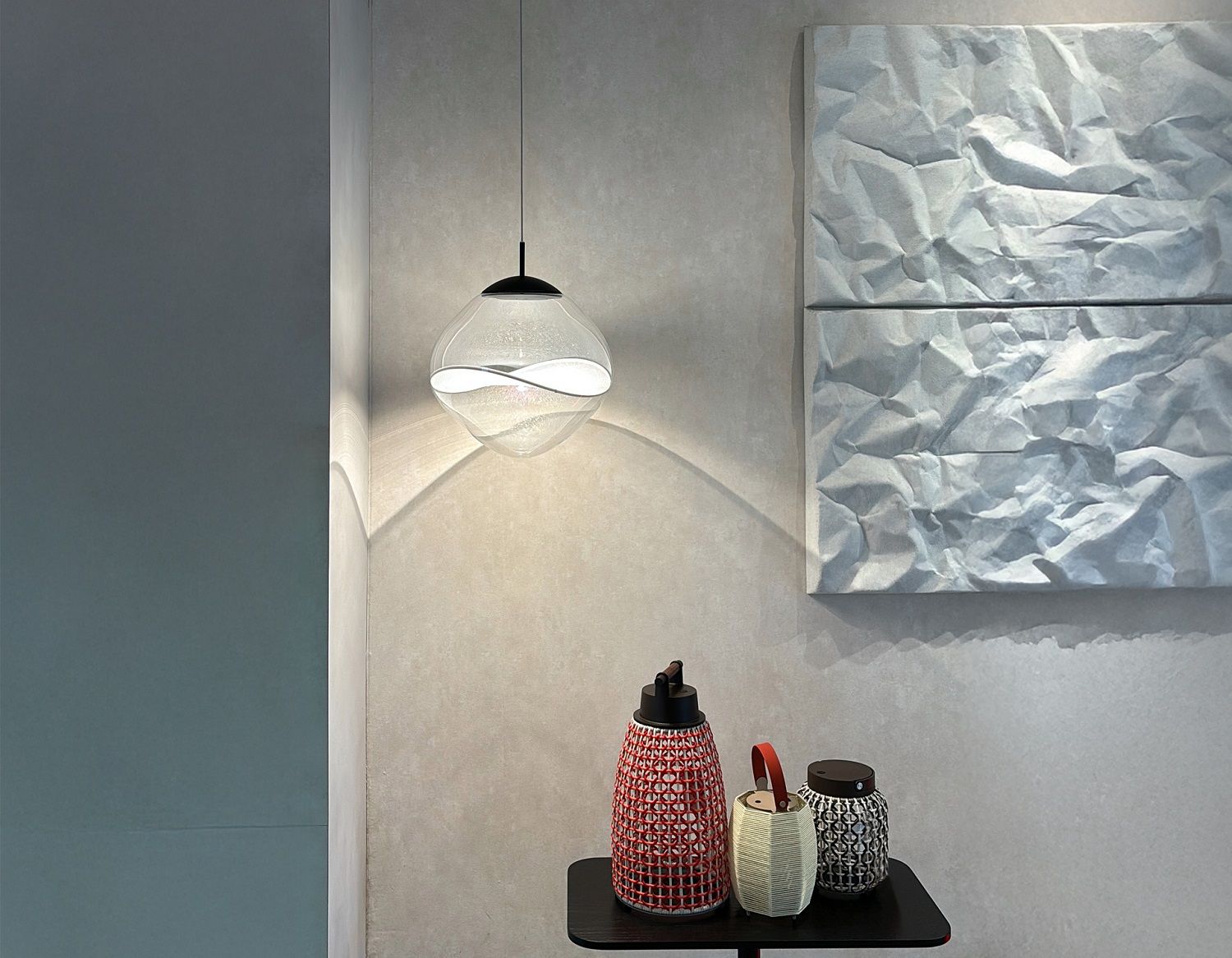 Aether Pendelleuchte Lumina: Moderne Hängelampe mit transparentem Glasschirm und wellenförmigem Design im Interieur.