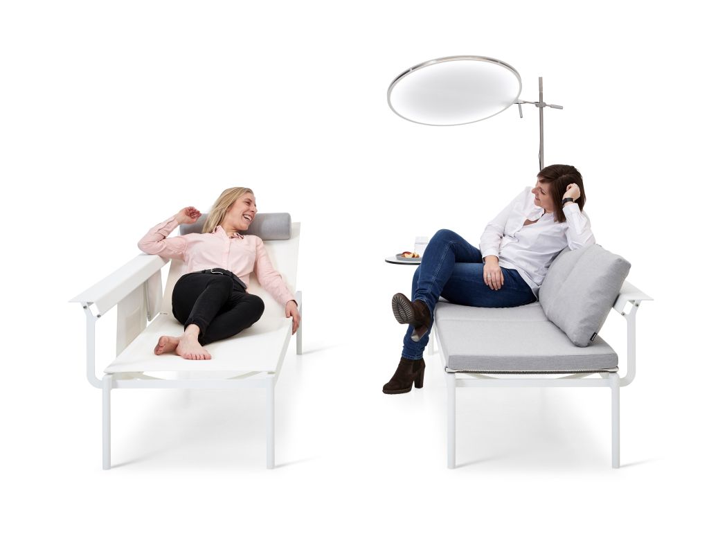 Zwei Frauen entspannen auf der Sol + Luna Outdoor Sonnenliege von Extremis mit Sonnenschutz.