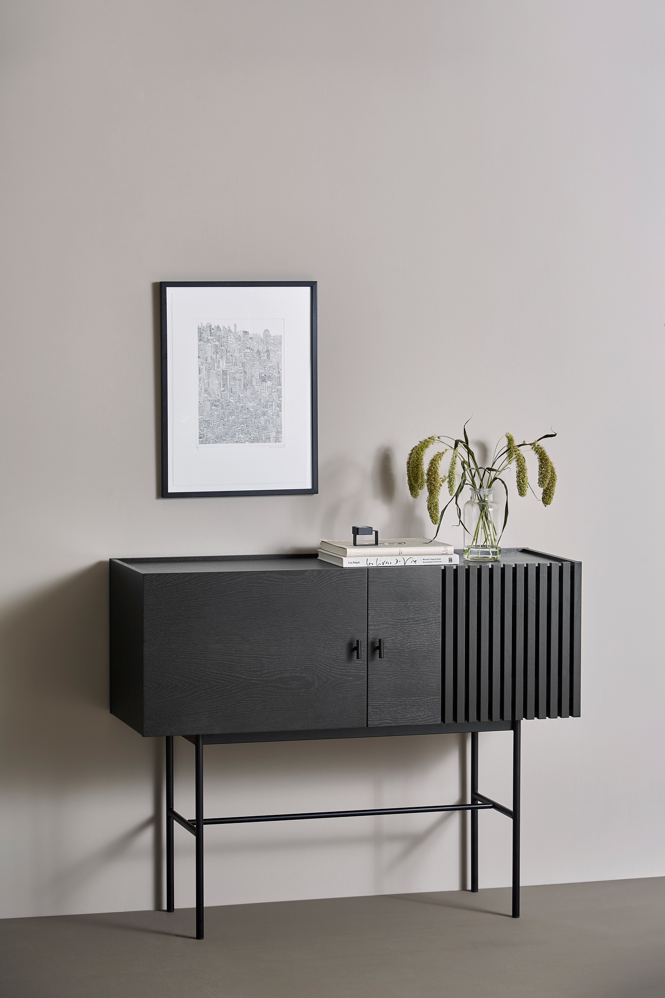 Schwarzes Array Sideboard von Woud (120cm) mit Türen und Lamellen, auf schlanken Beinen.