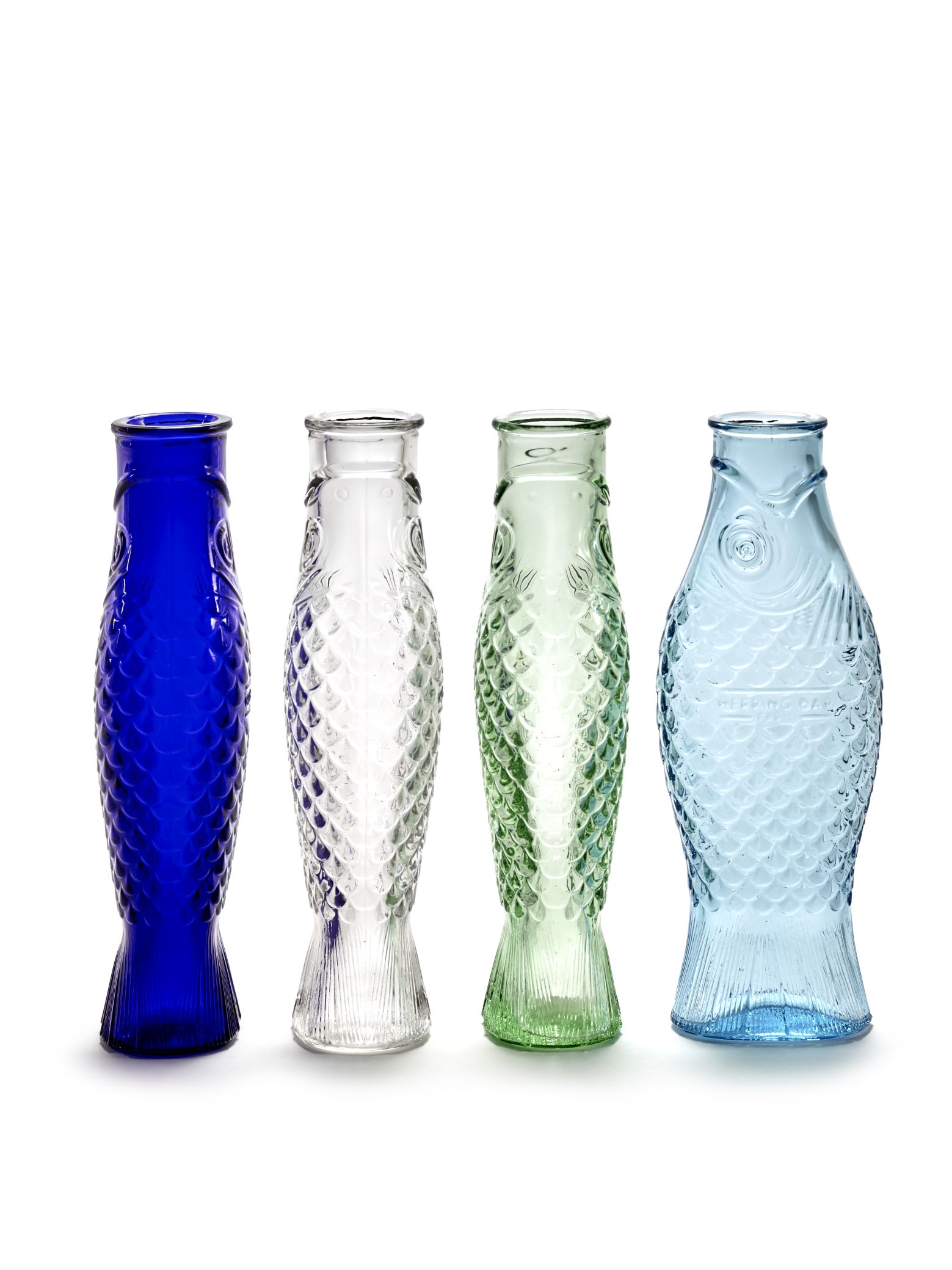 Vier bunte Fisch-Flaschen aus Glas, darunter eine grüne Serax Flasche, auf weißem Hintergrund.
