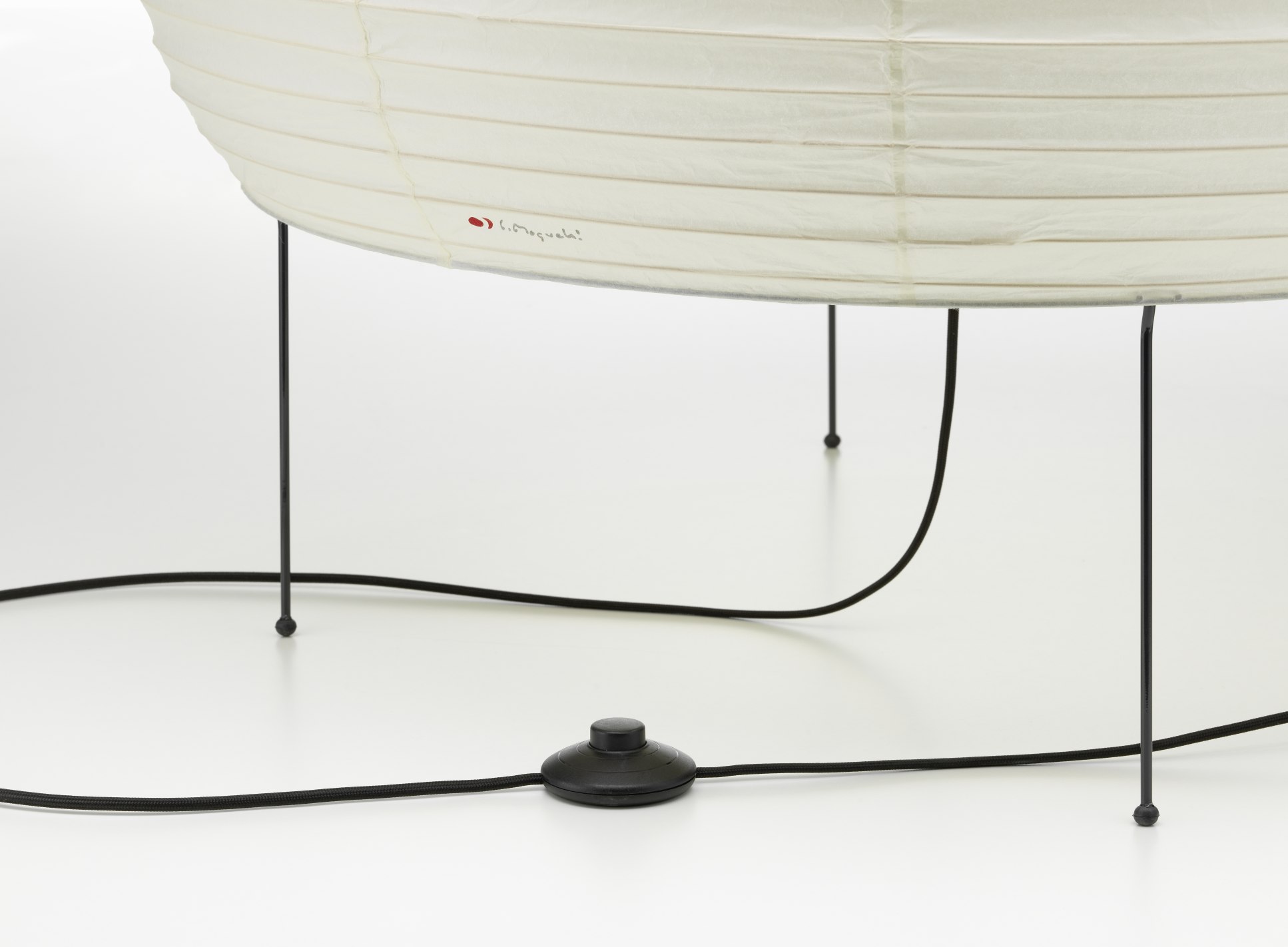 Detailaufnahme der Akari 25N Stehleuchte von Vitra, mit Papierschirm, schwarzem Kabel und Fußschalter.