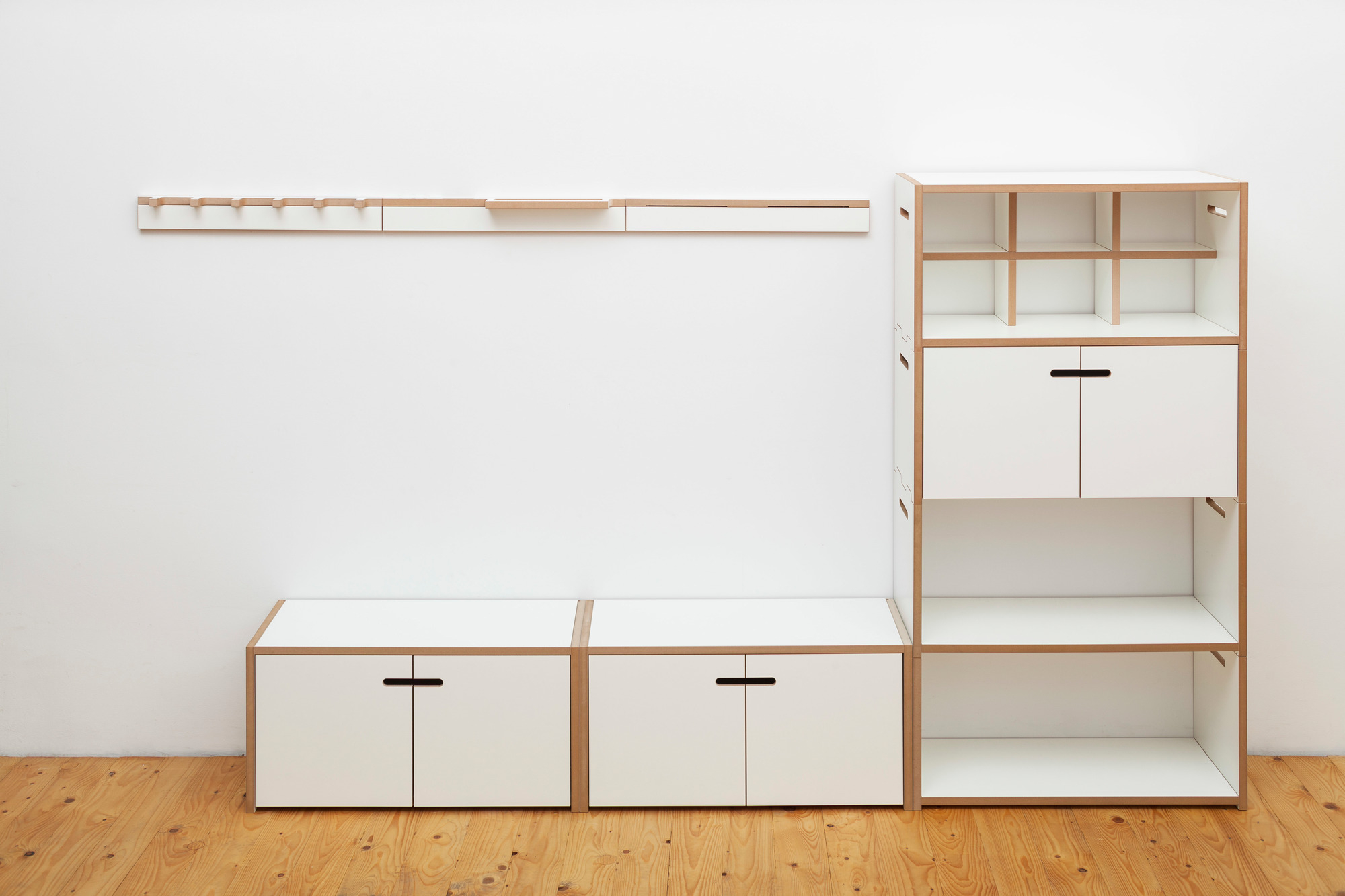 Grad Ablage von Tojo: Modulares Regalsystem mit weißen Schränken, offenen Fächern und Hängeleiste.