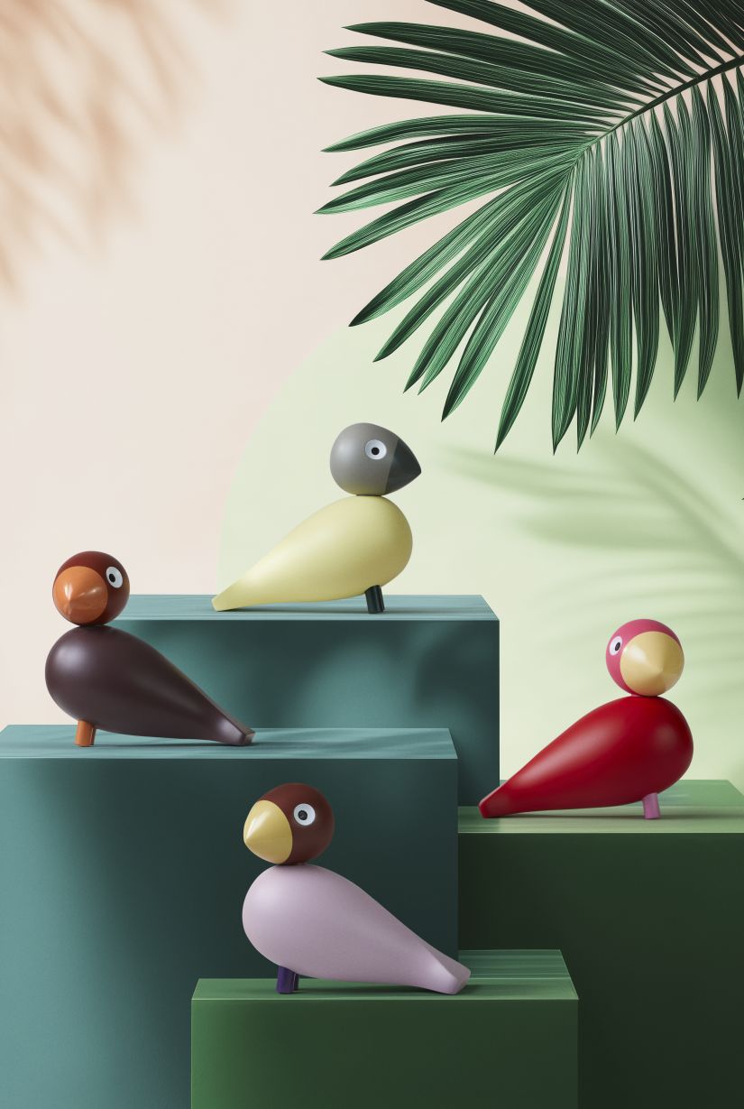 Kay Bojesen Year Birds 2025: Vier Holzfiguren in Beige, Grau, Rot, Braun und Rosa auf grünen Blöcken.