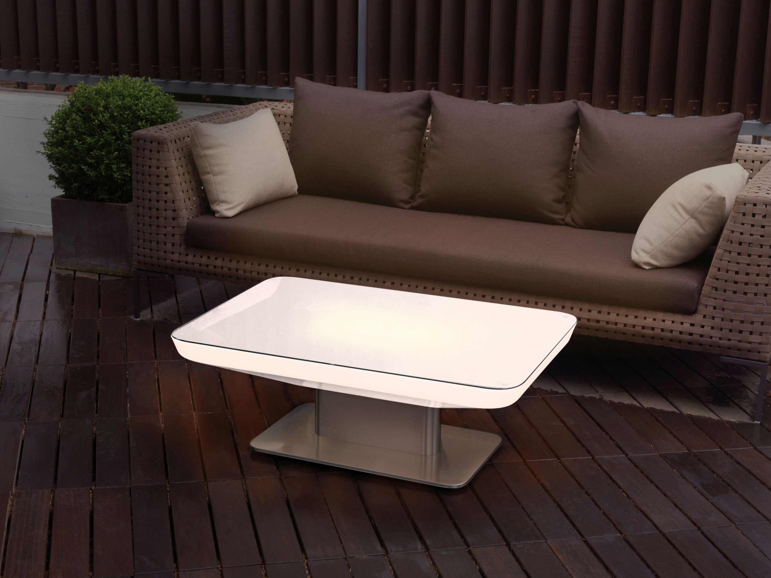 Studio 36 Tisch von Moree: Moderner Indoor Tisch mit Glasplatte und Metallfuß neben braunem Sofa.