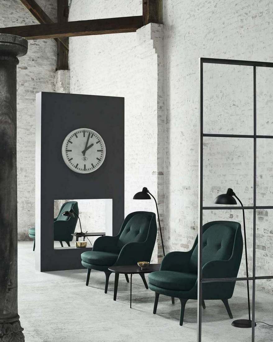 Zwei grüne Fri Sessel von Fritz Hansen mit kleinem Tisch und Stehlampen in Loft-Atmosphäre.