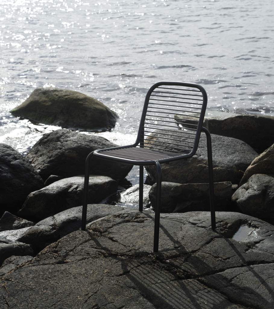 Schwarzer Vig Chair Stuhl von Normann Copenhagen steht auf Felsen am Wasser, Outdoor-Möbel.