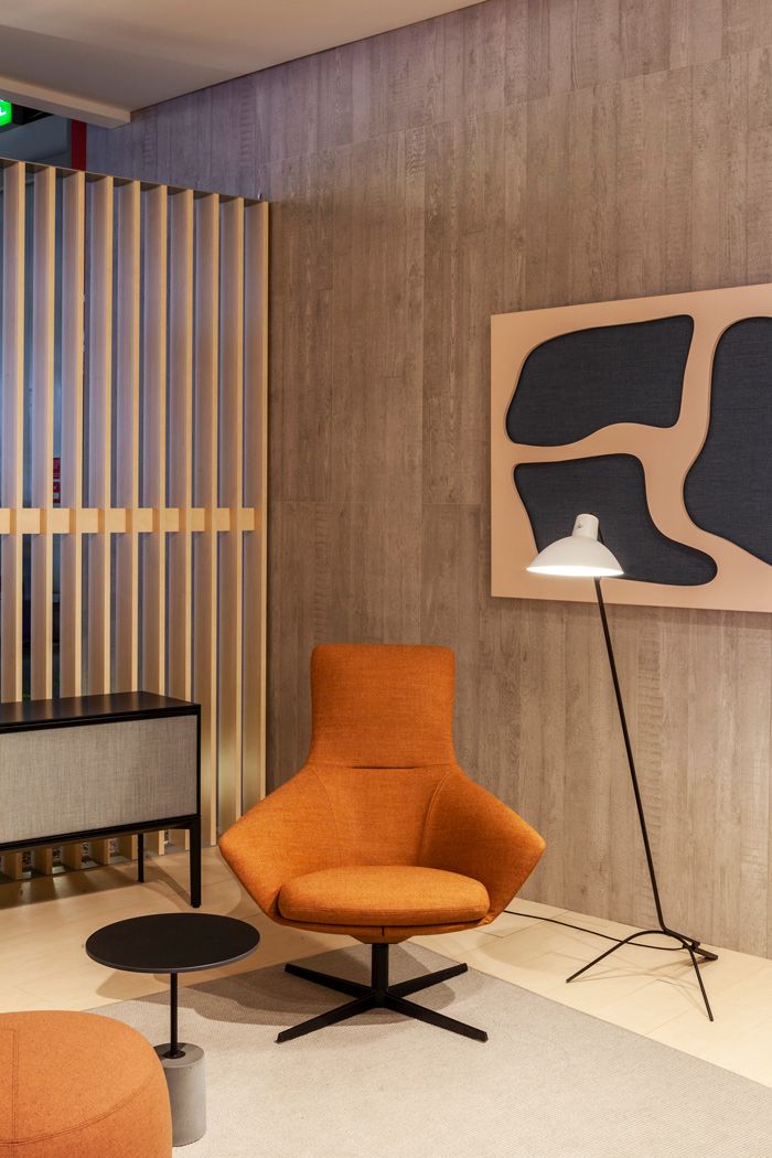 Orangefarbener Wing Tip S281 Lounge Sessel von La Palma mit schwarzem Fußkreuz in modernem Wohnzimmer.