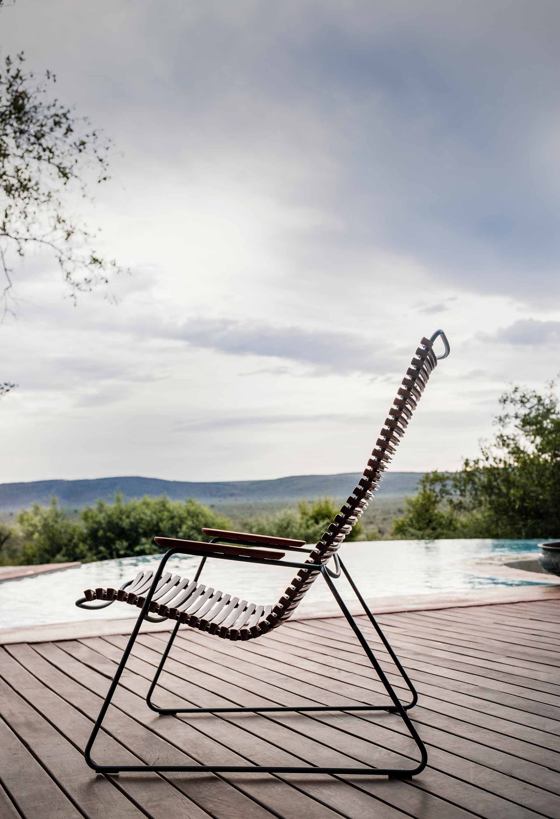 Dunkelgrauer Click Lounge Chair Sessel von Houe für den Außenbereich auf einer Holzterrasse am Pool.