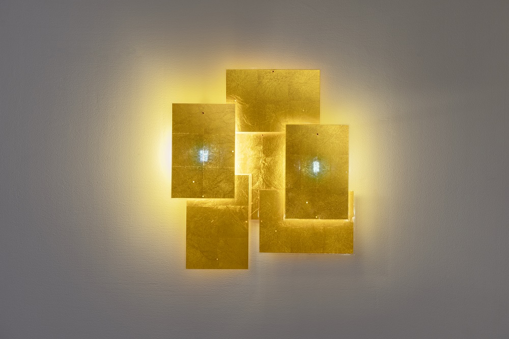 Nahaufnahme der 24 Karat Blau Wandleuchte von Ingo Maurer, goldene Quadrate an einer Wand.