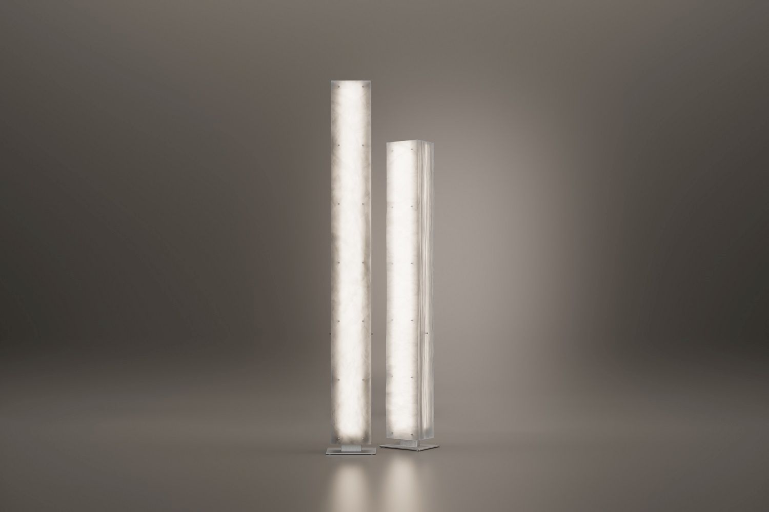 Zwei moderne Totem Stehleuchten im Stelen-Design, vertikal und beleuchtet, für stimmungsvolle Raumbeleuchtung.
