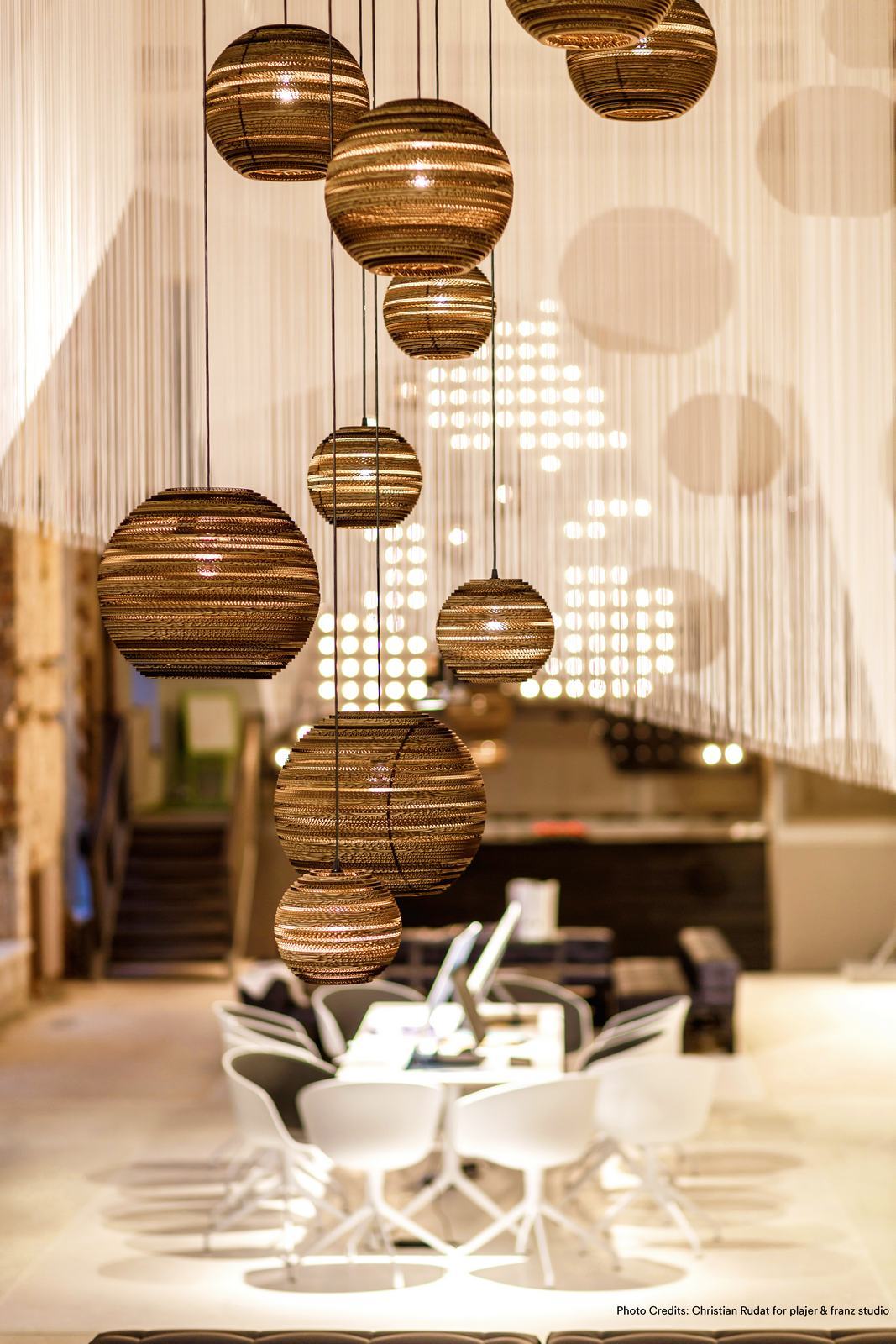 Mehrere Moon14 Scraplights Hängeleuchten von Graypants aus recycelter Pappe in einem modern eingerichteten Raum.