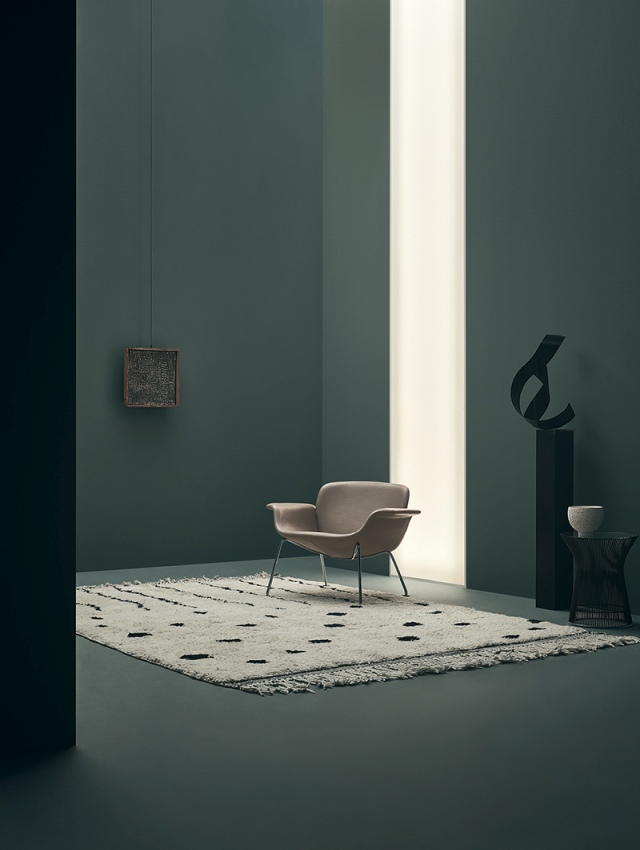 KN04 Stuhl von Knoll International, beiger Sessel mit Armlehnen auf einem gemusterten Teppich.