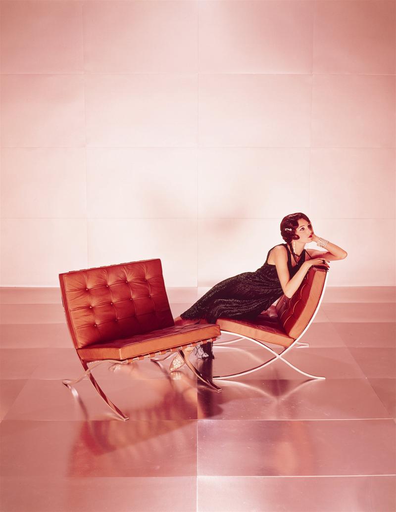 Frau entspannt auf einem braunen Barcelona Sessel, Designklassiker von Knoll International.