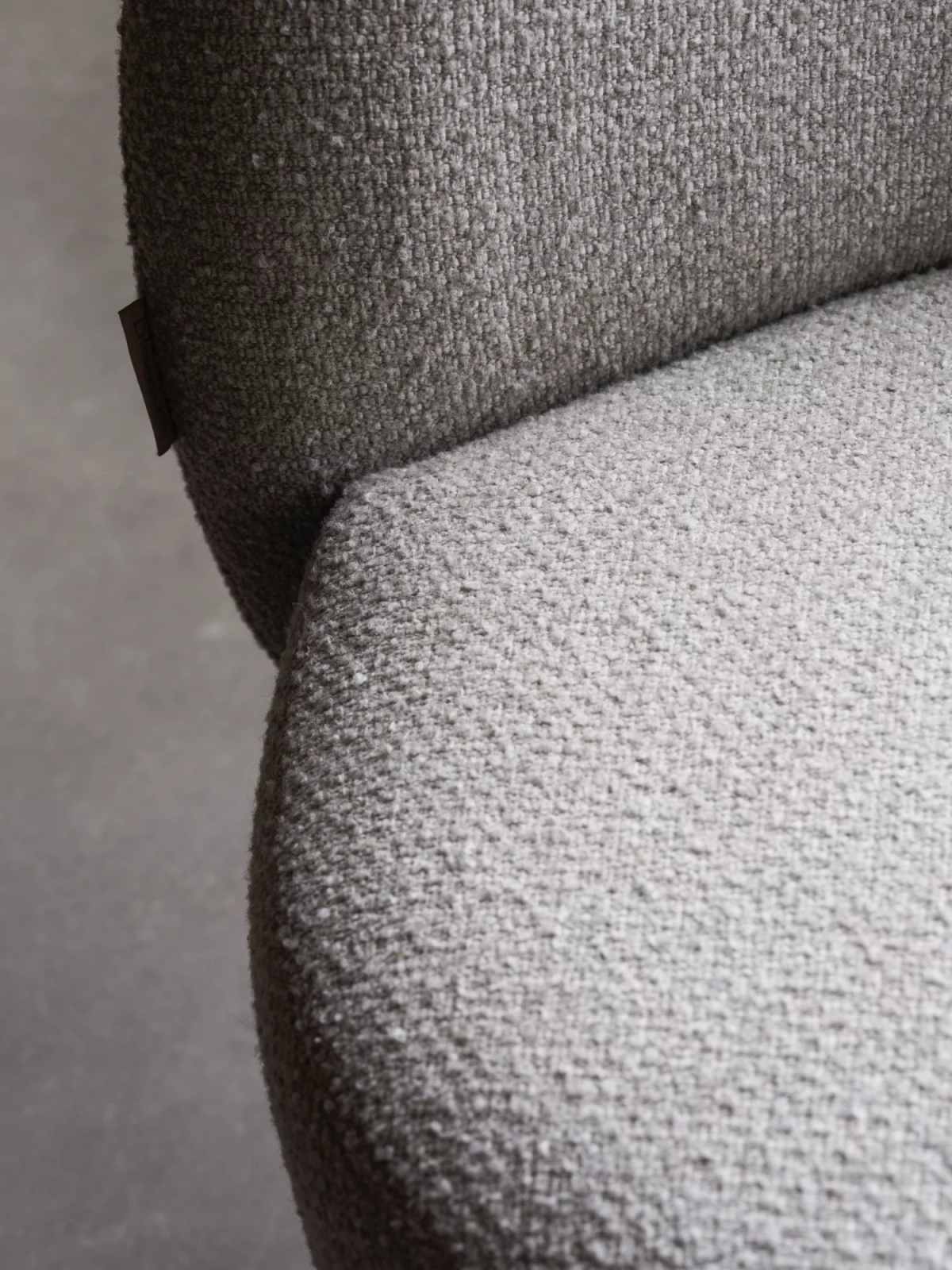 Detailaufnahme des grauen Kuon Sessels von Blomus mit weicher, strukturierter Polsterung.