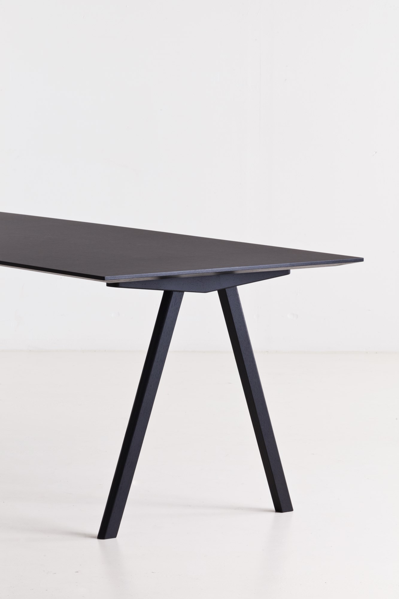 Detailaufnahme des Copenhague Table CPH 10 Tisches von Hay in Schwarz, minimalistisches Design mit schrägen Tischbeinen.