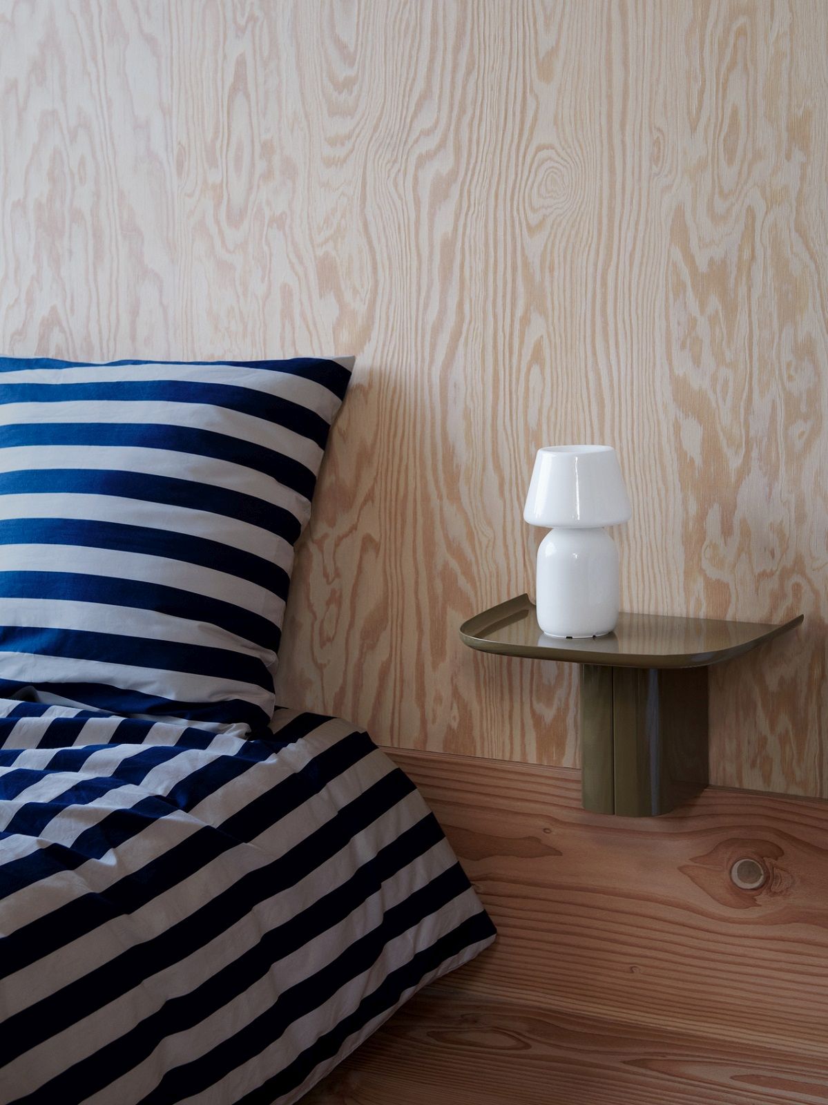 Korpus Shelf Small von Hay, ein grünes Wandregal mit Lampe neben einem Bett.