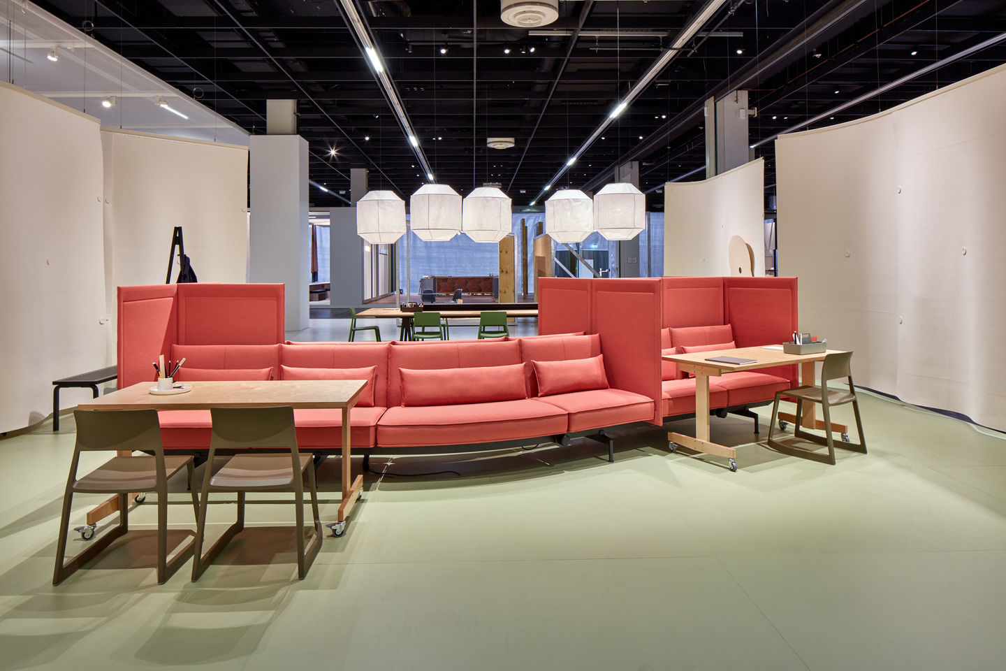 Innenaufnahme eines modernen Büros mit Tischen, Sitzgelegenheiten und einem Vitra Tip Ton RE Stuhl in Soft Grey.