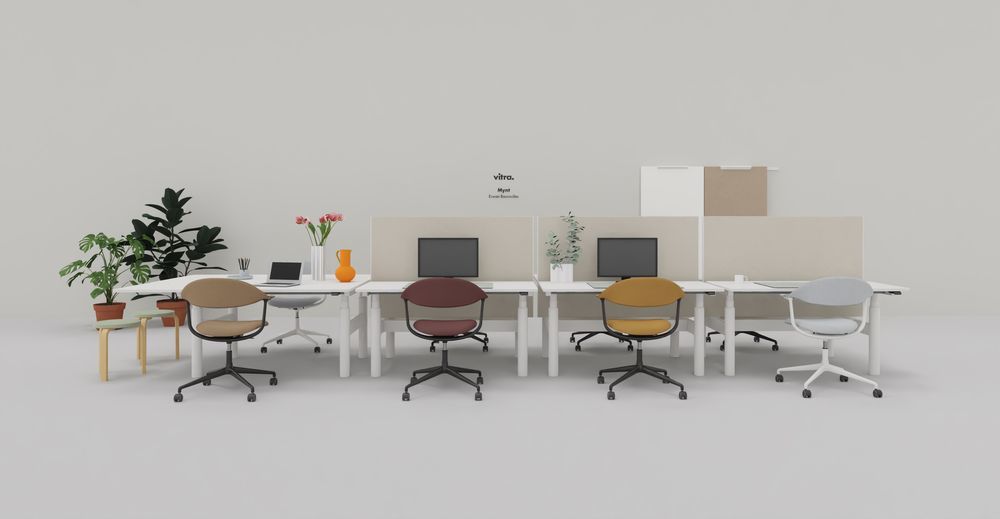 Vitra Mynt Bürodrehstühle aus Schichtholz in verschiedenen Farben an weißen Schreibtischen im modernen Büro.