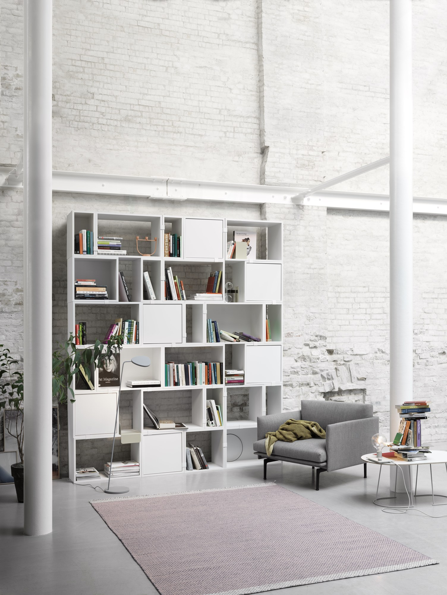 Dunkelgrüne Muuto Leaf Stehleuchte im Wohnzimmer mit Bücherregal und Sessel. Moderne Bodenleuchte.