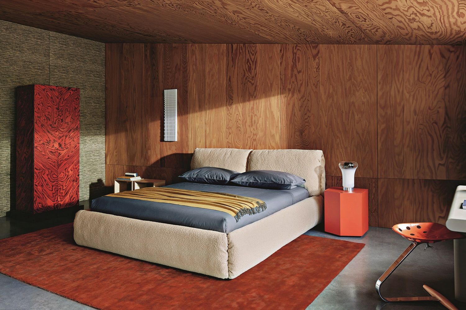 Schlafzimmer-Szene mit Zanotta Z24 Nachttisch in Rot, Lampe und Teppich für stimmungsvolle Einrichtung.