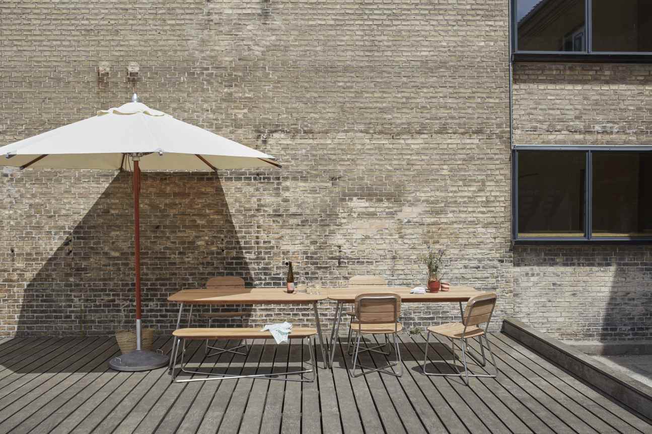 Capri Sonnenschirm mit Skagerak by Fritz Hansen Sonnenschirmfuß (50 kg) auf Holzterrasse.