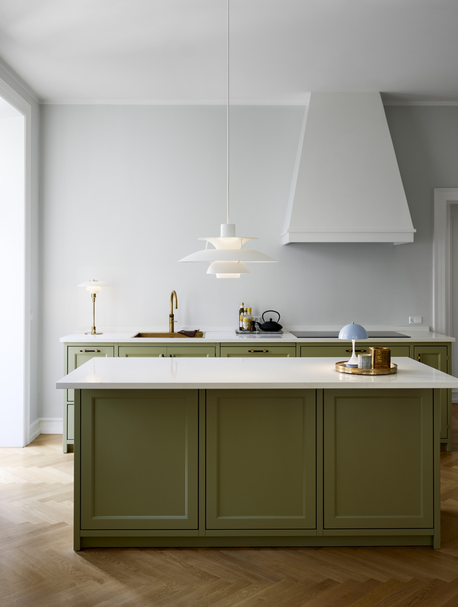Helle Küche mit PH 5 Pendelleuchte von Louis Poulsen in Pastellfarben über Kücheninsel.