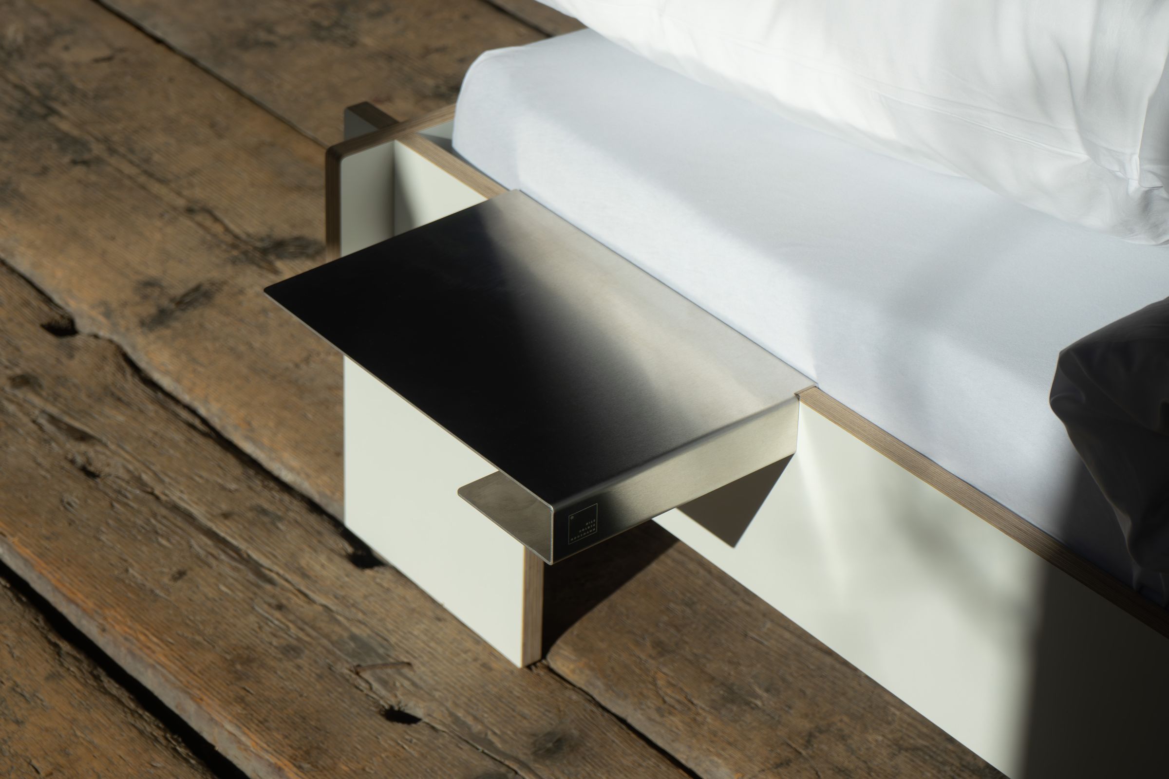 Nils Holger Moormann Bett mit Bettkante Leicht Ablage aus Edelstahl und weißem Holz.
