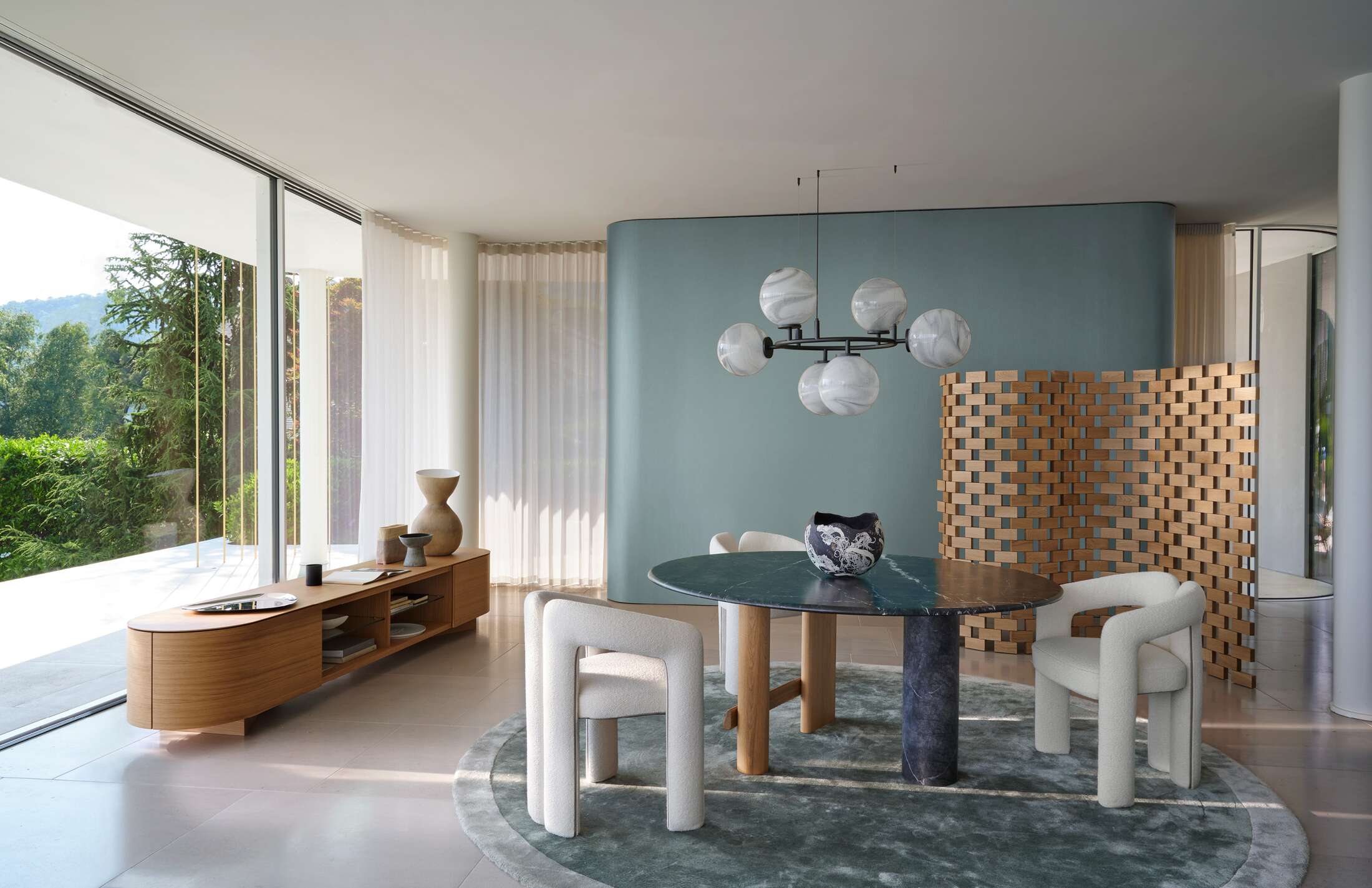 Helles Esszimmer mit Cassina 562 Dudet Sessel in Weiß, Marmortisch und moderner Einrichtung.