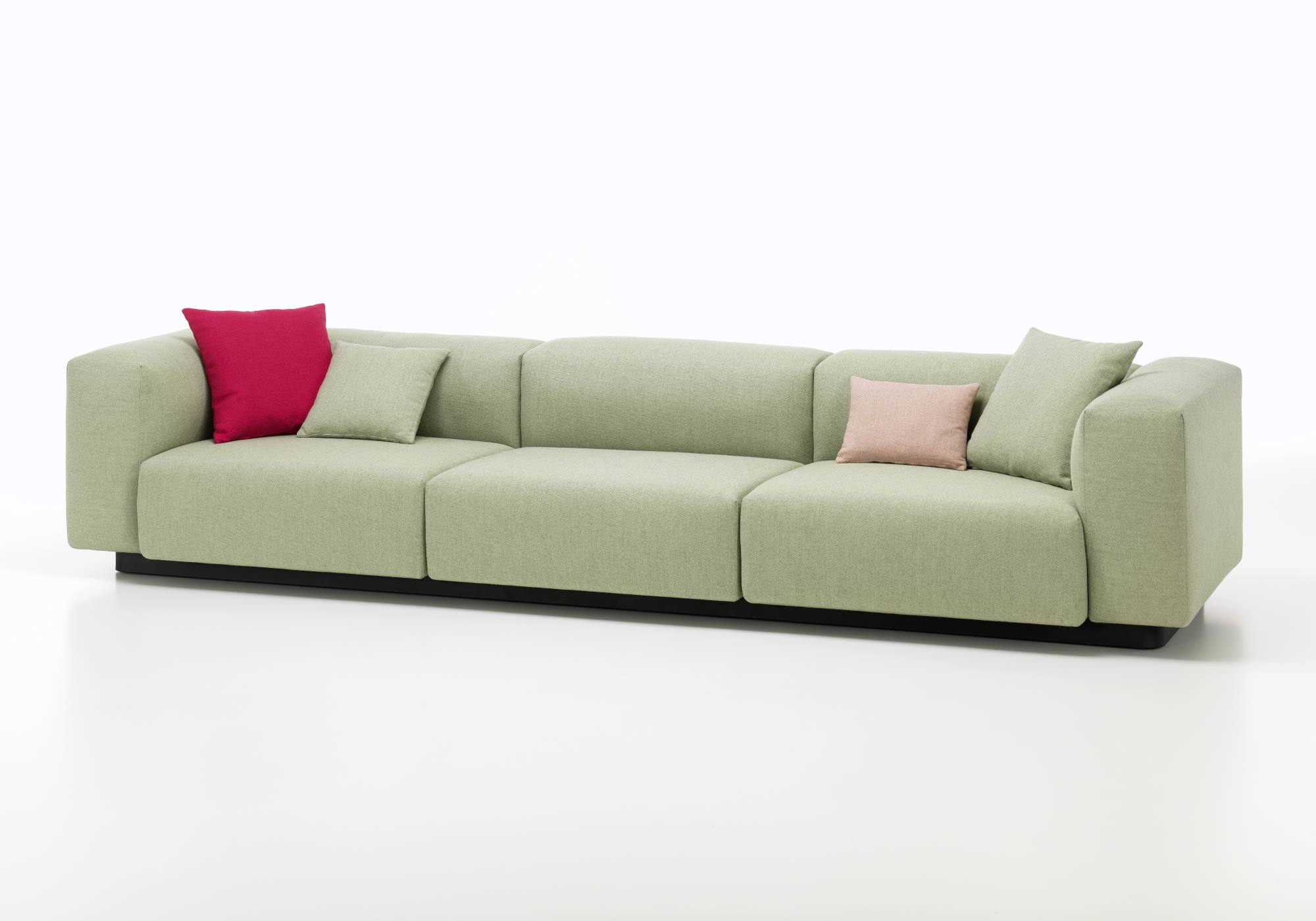 Vitra Soft Modular Sofa Dreisitzer in Hellgrün mit roten und rosa Kissen auf weißem Hintergrund.