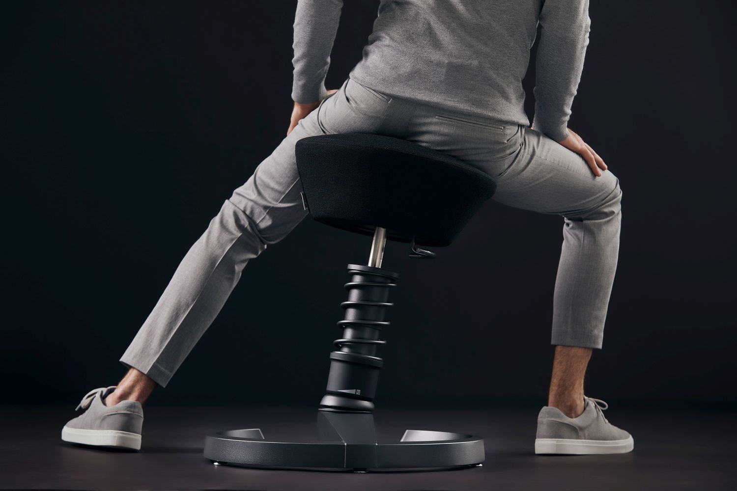 Ergonomischer Stehsitz mit schwarzem Sitzpolster und spiralförmiger Säule für dynamisches Sitzen im Büro.