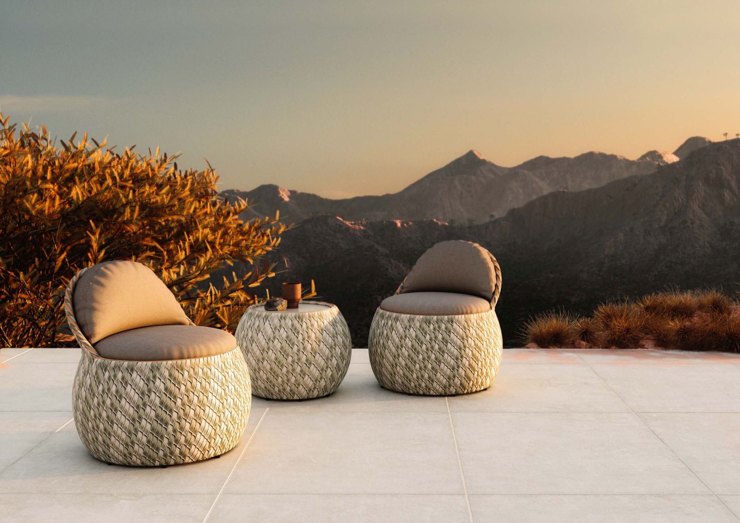 Dala Beistelltisch von Dedon mit zwei passenden Sesseln auf einer Terrasse mit Bergblick.