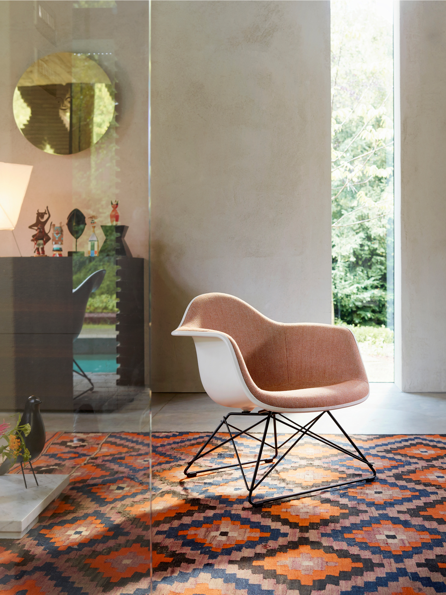 Eames Fiberglass Chair DSW Stuhl in Navy Blue mit Ahorn-Gestell auf gemustertem Teppich.