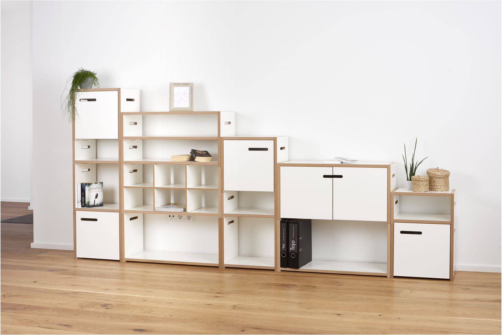 Modernes, modulares Regalsystem in Weiß und Holzoptik für Wohnzimmer und Büro. Vielseitige Aufbewahrungslösung mit Fächern und Schubladen.