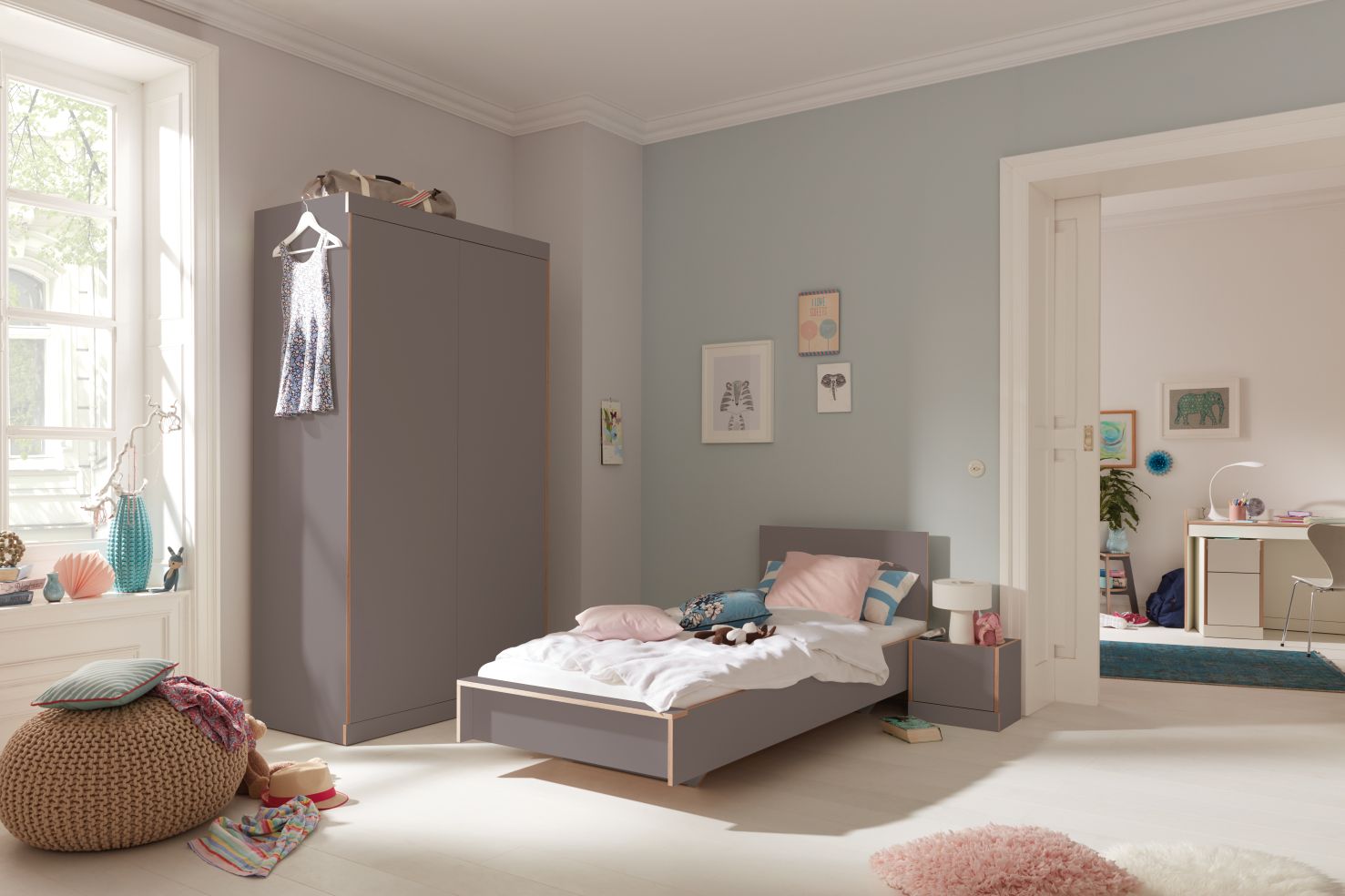 Helles Kinderzimmer mit Flai Bett von Müller Möbelwerkstätten und passendem Kleiderschrank in Grau.
