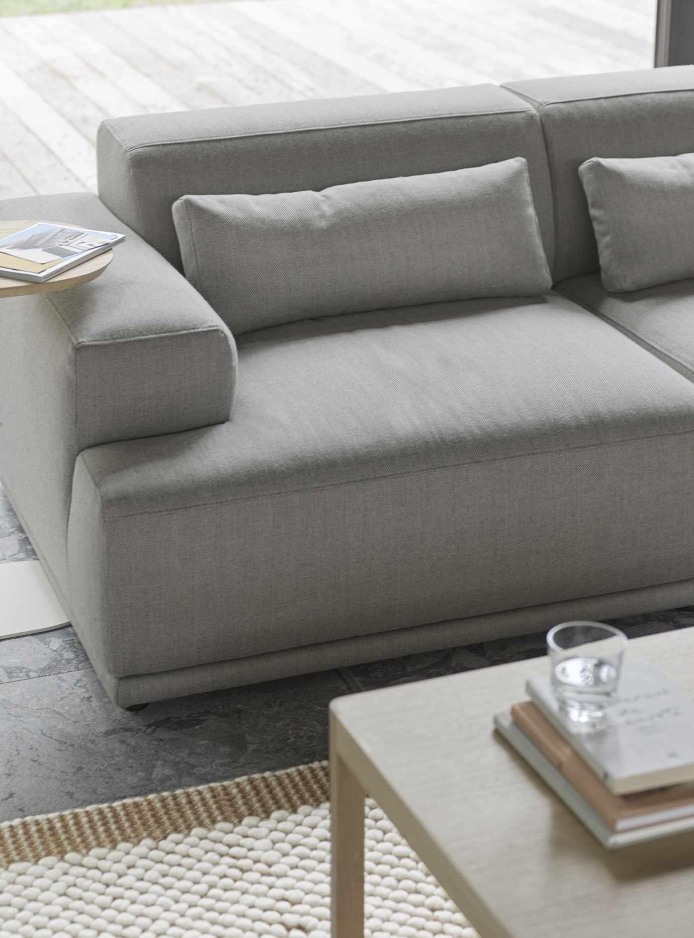 Nahaufnahme des modernen Muuto Connect Soft Modular Ecksofas Clay 12, Konfiguration 3, mit Kissen und Beistelltisch.