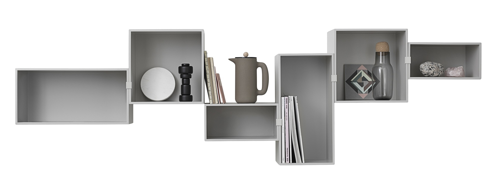 Graues Mini Stacked Regalsystem von Muuto mit Deko-Objekten wie Kanne, Flasche, Büchern und Steinen.