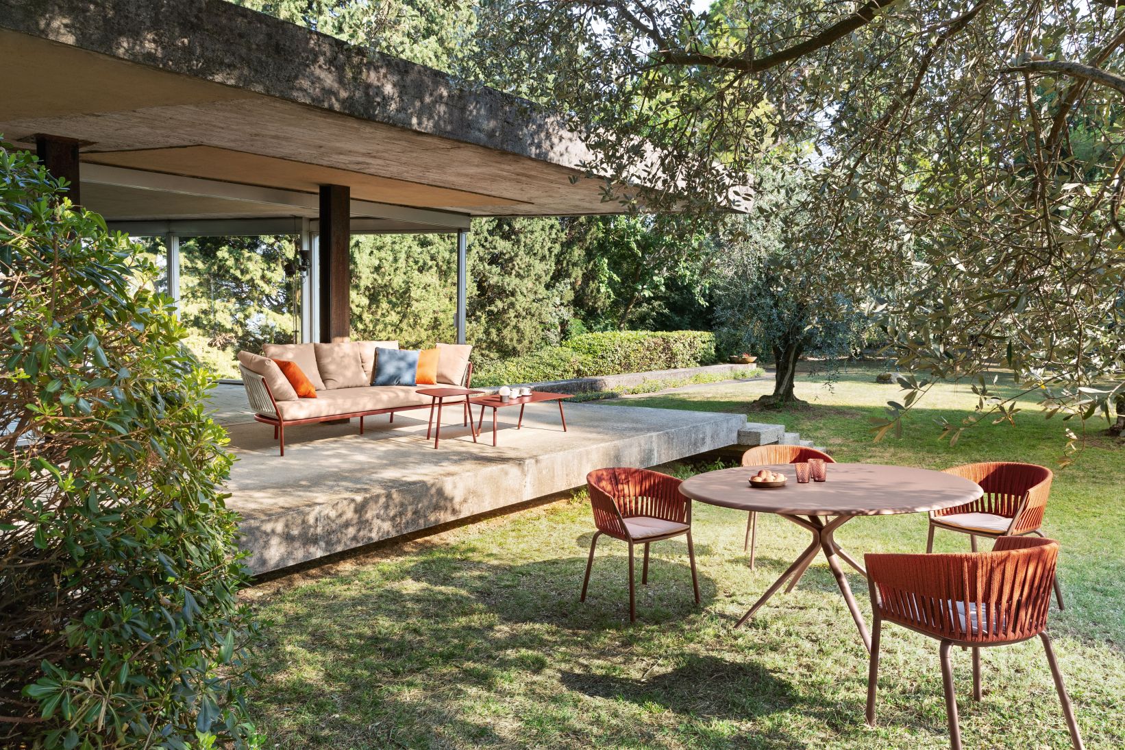 Ria Stuhl von Fast mit passendem Gartentisch und Sofa im Außenbereich auf Rasen.