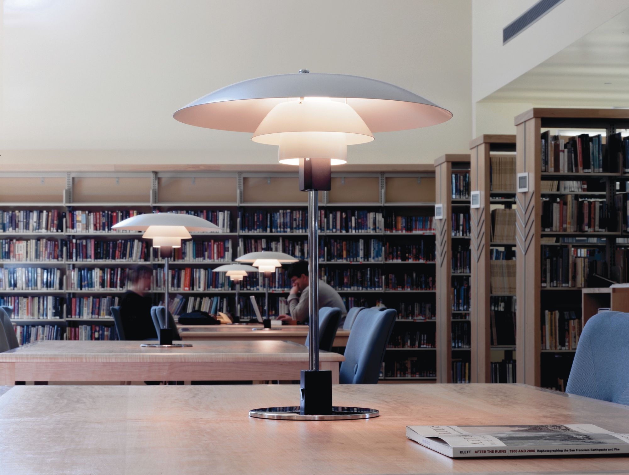PH 4/3 Tischleuchte von Louis Poulsen auf einem Tisch in einer Bibliothek. Design Lampe.
