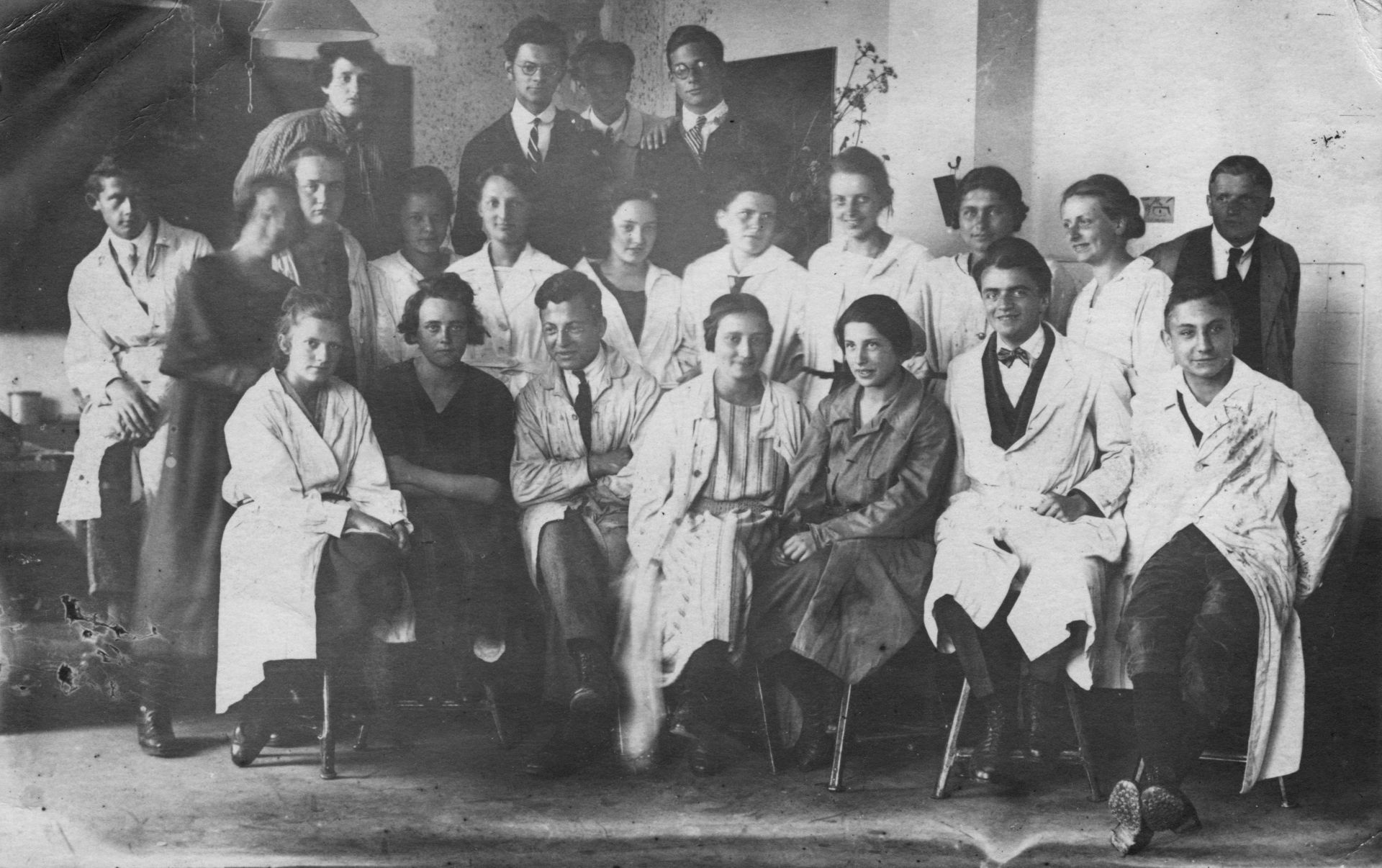 Schwarz-Weiß-Foto einer Gruppe von Studenten und Professoren in Laborkitteln, historische Aufnahme für wissenschaftliche Forschung.