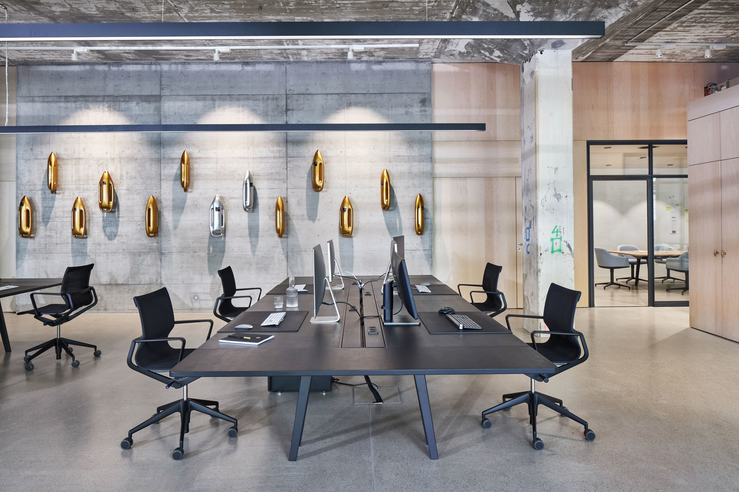 Moderner Büroraum mit schwarzem Konferenztisch und Physix Studio Bürodrehstühlen von Vitra für ergonomisches Sitzen.