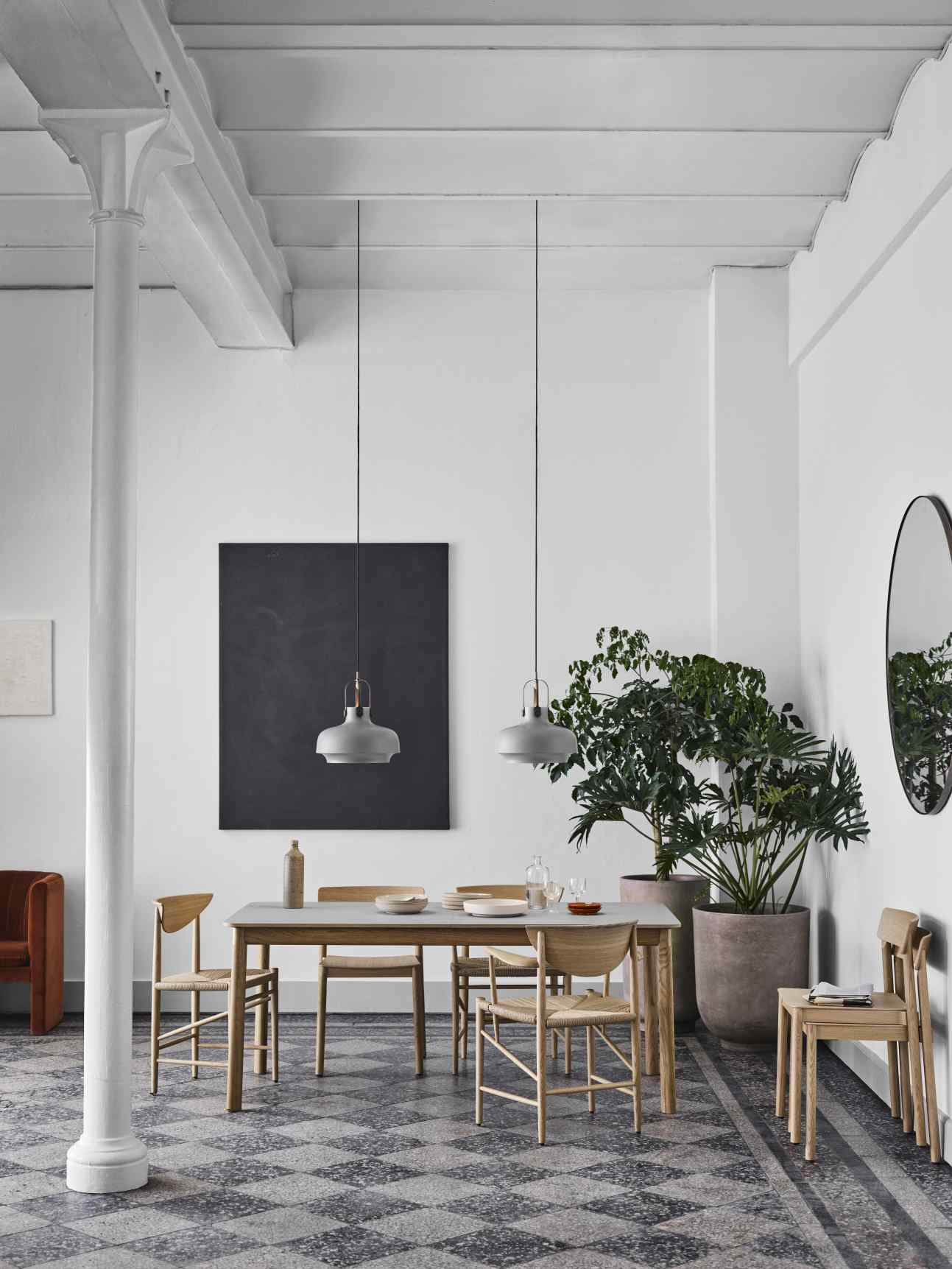 Esszimmer mit AndTradition Amore Spiegel, rund, schwarz gerahmt, an weißer Wand. Dekorative Spiegel für stilvolles Wohnen.