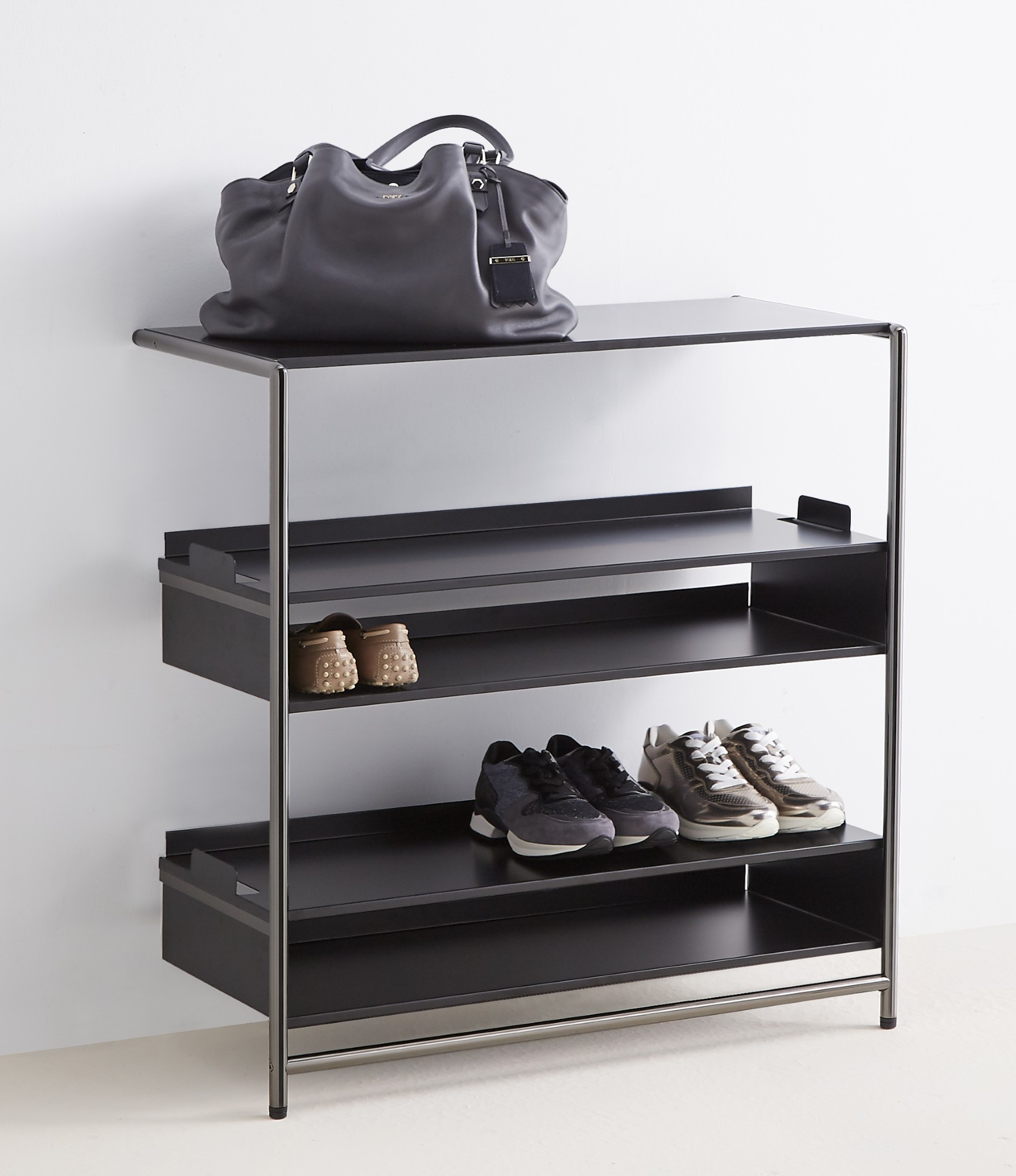 Schwarzes Mox Pool 82 Anlehnregal mit Schuhen und Tasche. Spezialtablaren für flexible Nutzung.