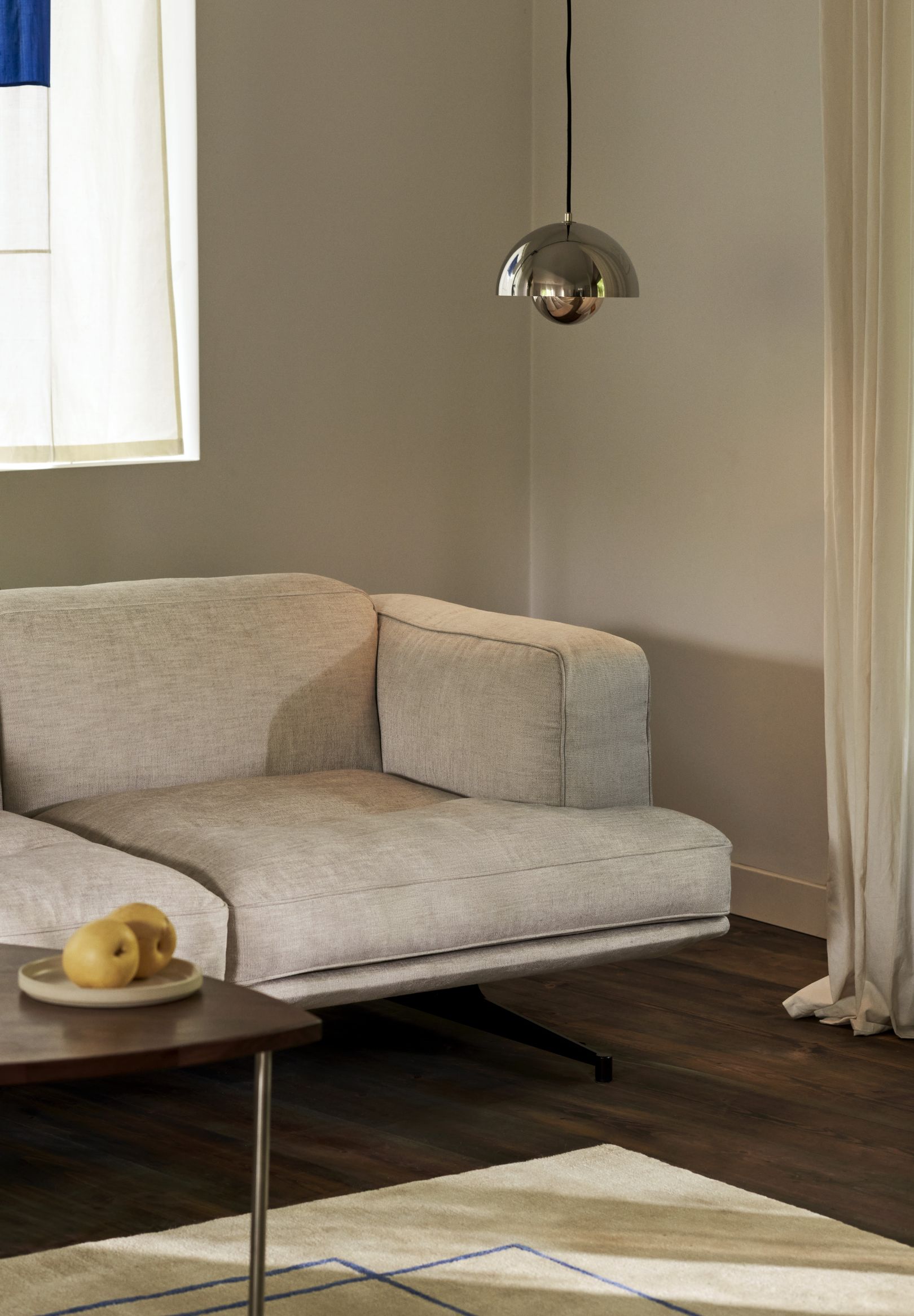 Helles AndTradition AV23 Sofa mit minimalistischem Design, passendem Teppich und Beistelltisch im Wohnzimmer.