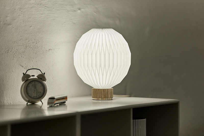 Le Klint Tischleuchte Model 375 mit Eichenfuß und plissiertem Papierschirm.